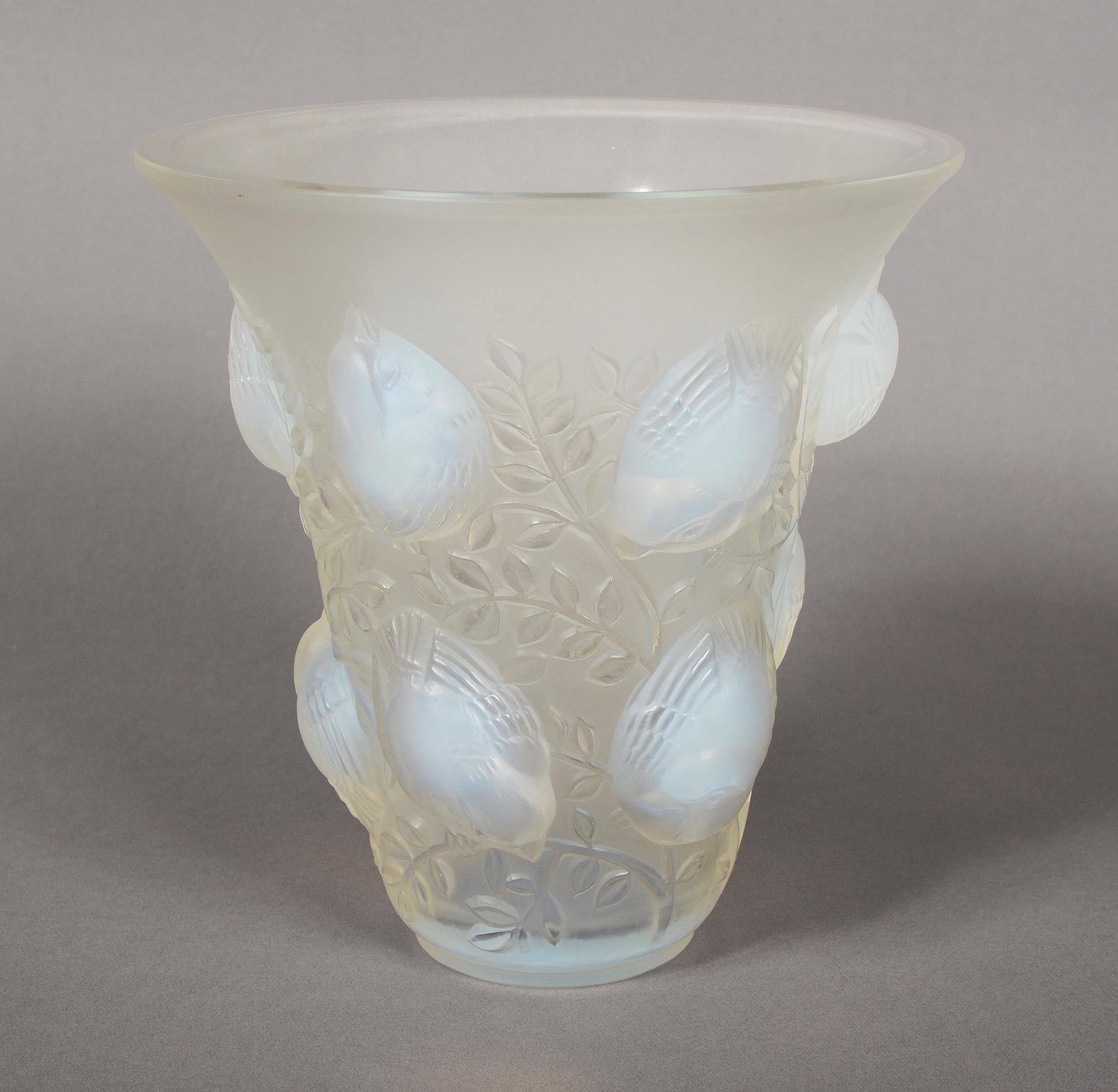 Saint Francois opalescent vase designed by René Lalique, circa 1930. This example dates to circa 1945 just before production ended for this design. The vase is decorated with chubby sparrows on branches. There is a small nick to the side of the rim