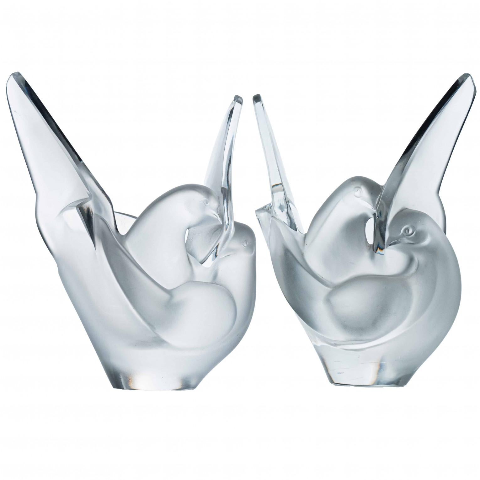 Lujo en estado puro, este par de jarrones Love Birds de cristal de alta gama fabricados y firmados por Lalique.  La pieza, diseñada originalmente por Marc Lalique en 1956, tiene forma de dos palomas acurrucadas con las alas extendidas. Hay una