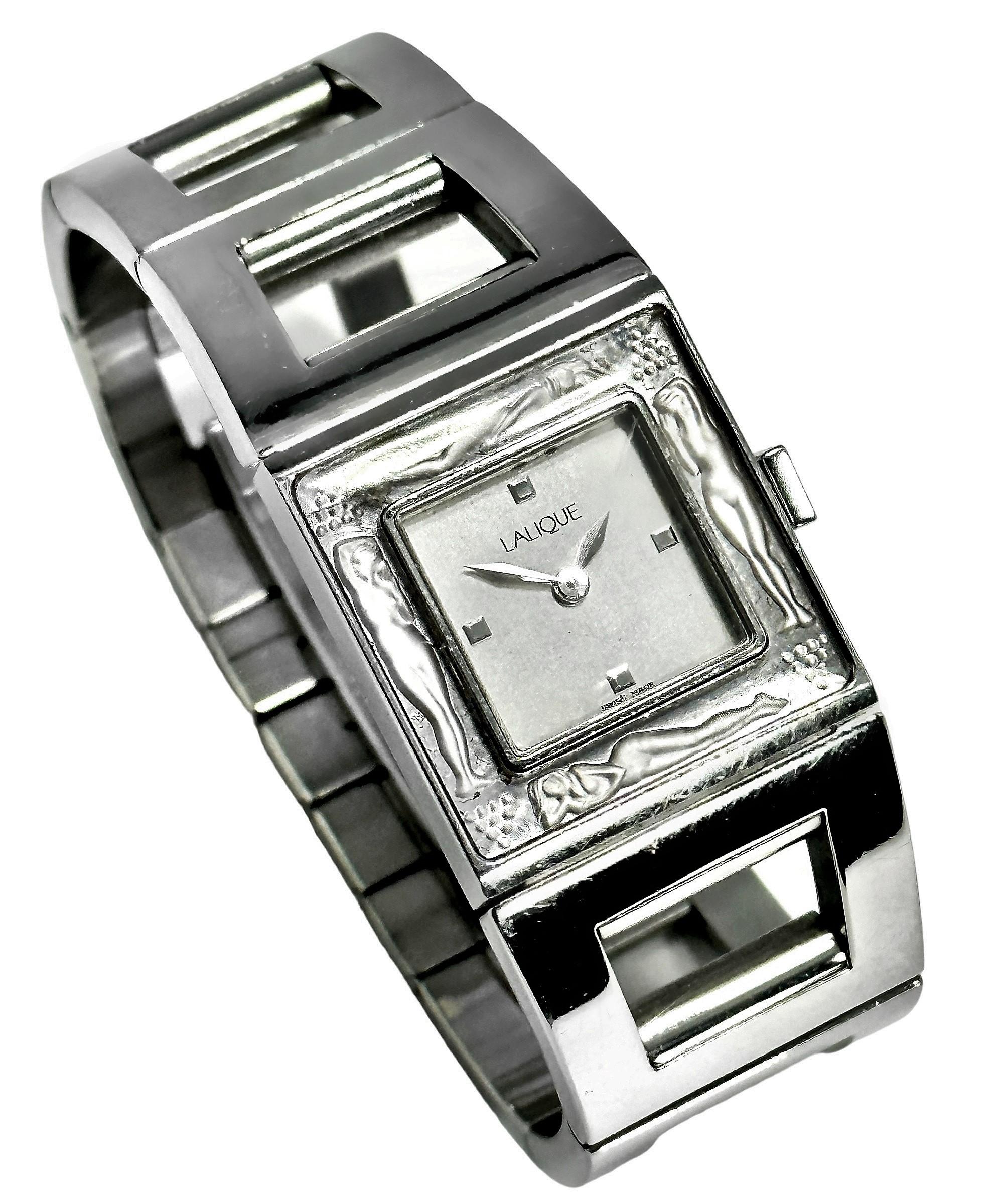 A stainless-steel ladies watch, with a case measuring 24mm wide. The bracelet features a square open link, which tapers from 24mm to 21mm at its double-deployment buckle. The bezel features four feminine bodies and four motifs carved in crystal. The