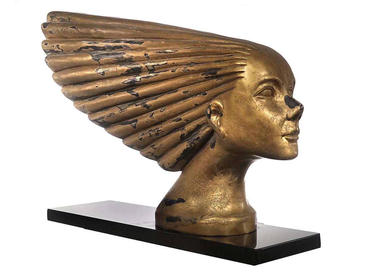 This is not a plaster, resin or plastic reproduction. This is a two foot long carved wood study for the Iconic Art Deco car mascot named Victoire. It has a gesso primer and a gold finish. There are warning areas that Revel the wood. Its design was