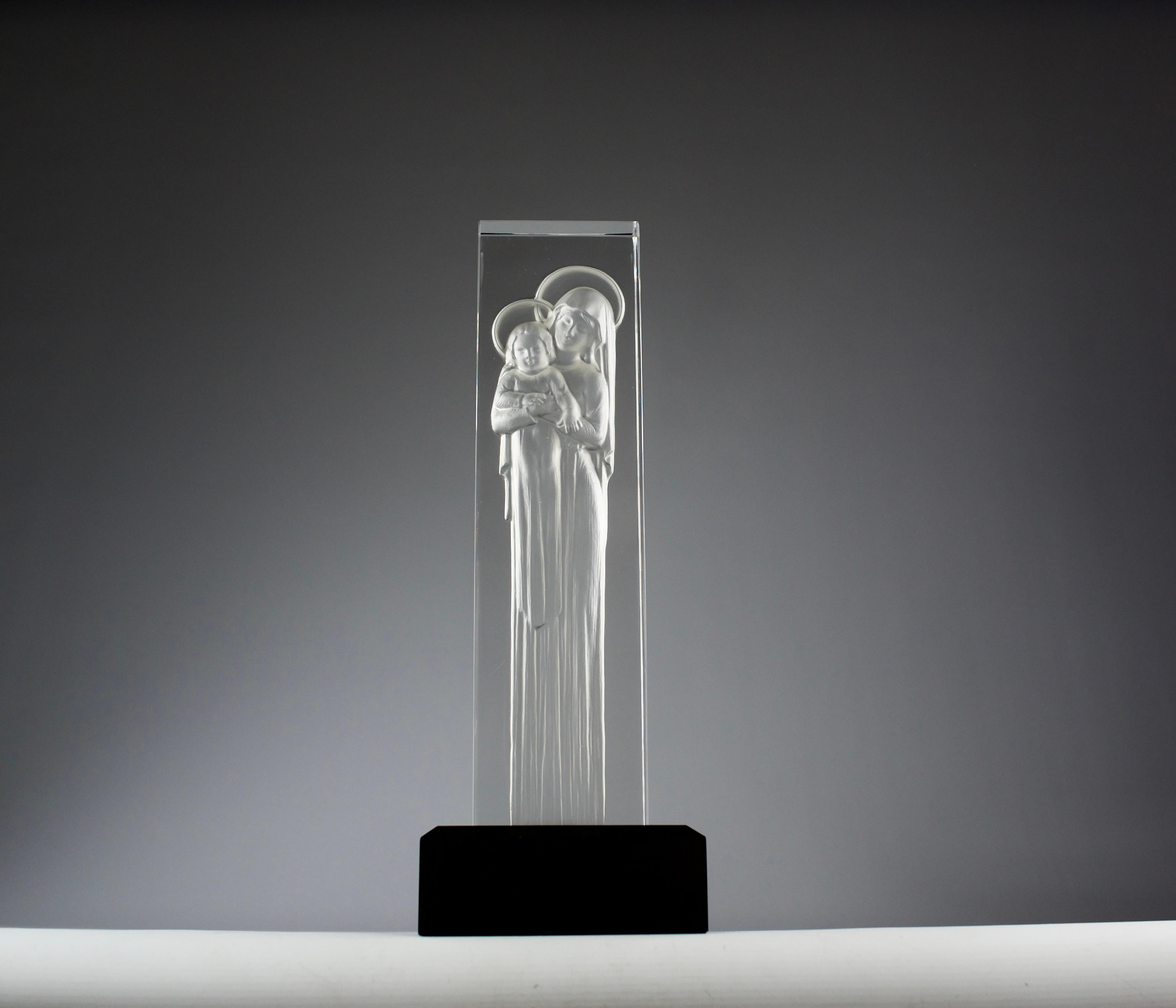 Superbe sculpture de la Vierge à l'enfant de Lalique sur un socle en bois laqué noir, France 1970. Magnifique forme en cristal qui capture la dévotion et la grâce du sujet. Conçue par René Lalique, celle-ci est une réédition posthume des années