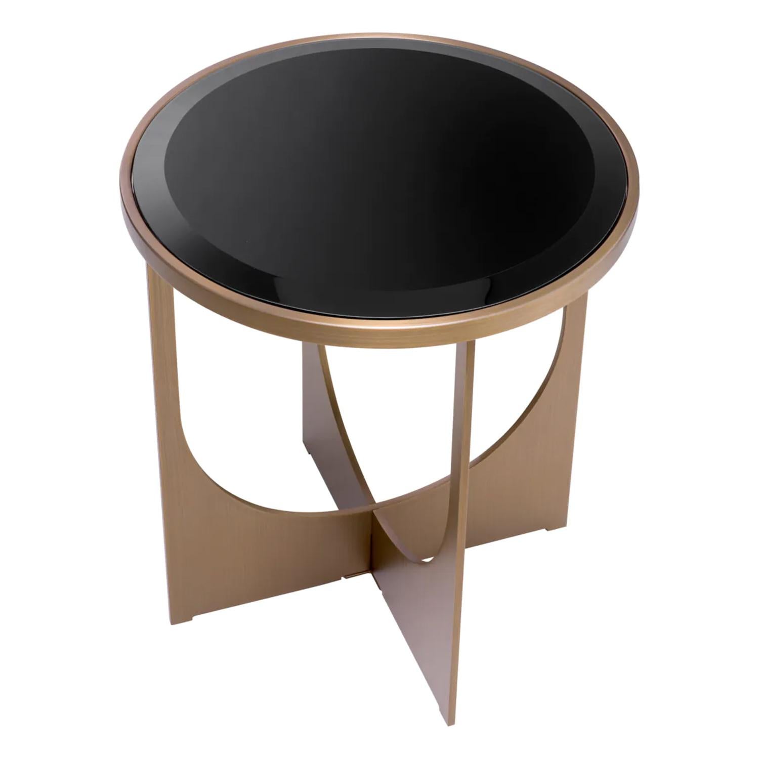 Table d'appoint Lally avec toute la structure en acier inoxydable en 
finition laiton brossé et plateau en verre noir biseauté.
