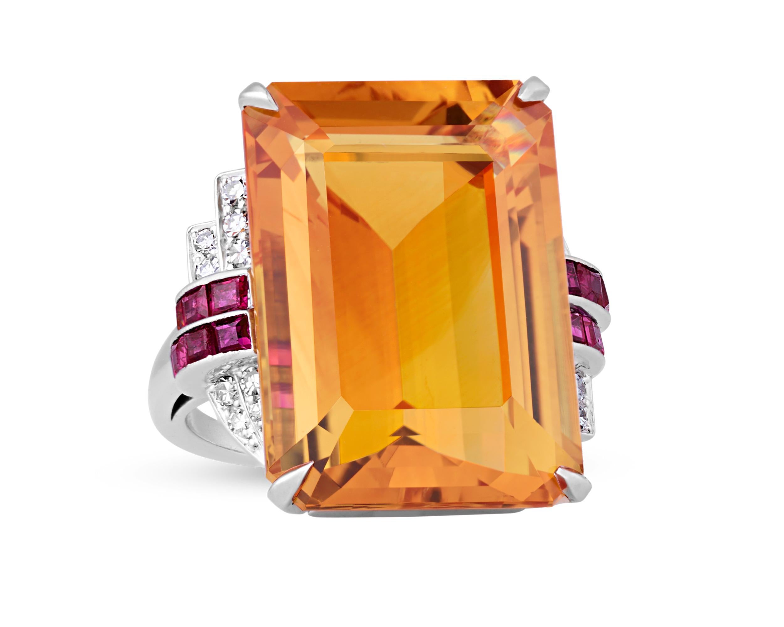 Radiating with bold Art Deco glamour, this exceptional ring by Lambert Brothers displays a vibrant 23.35-carat emerald cut citrine. Its rich honey-cognac hue reflects light with remarkable depth and warmth, showcasing the perfect golden tones that