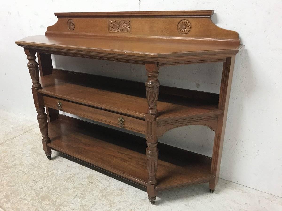 Lambs of Manchester. (Stamped to drawer). Attributed to Alfred Waterhouse
An Aesthetic Movement oak étagère, buffet or hall table.
The central stylised carved floral detail flanked by two carved sunflowers to the shaped back with turned and spiral