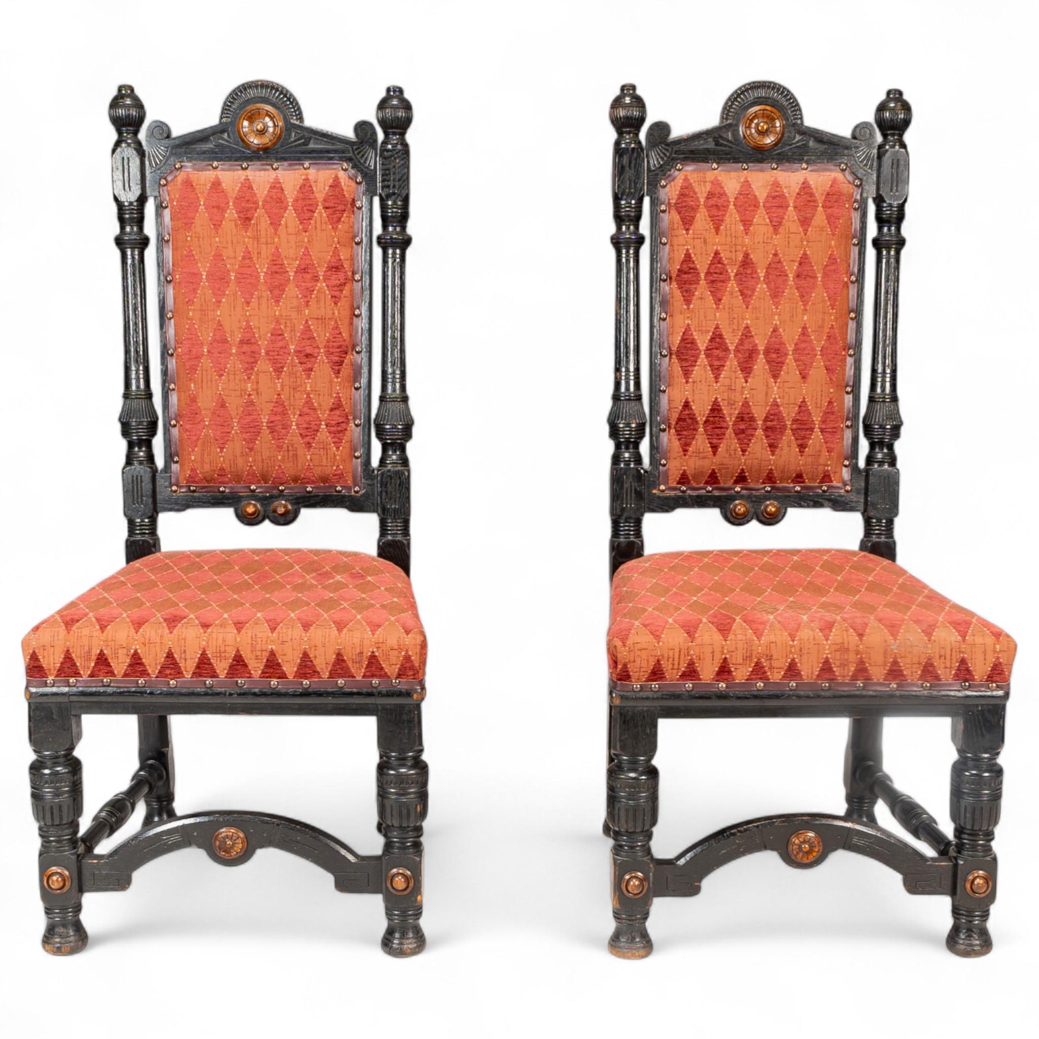 Lambs of Manchester.
A rare pair of exhibition quality Aesthetic Movement ebonized oak side chairs with a subtle Egyption style, inset with boxwood floral carved rosettes and boxwood buttons. The front legs united by an arched front stretcher stood