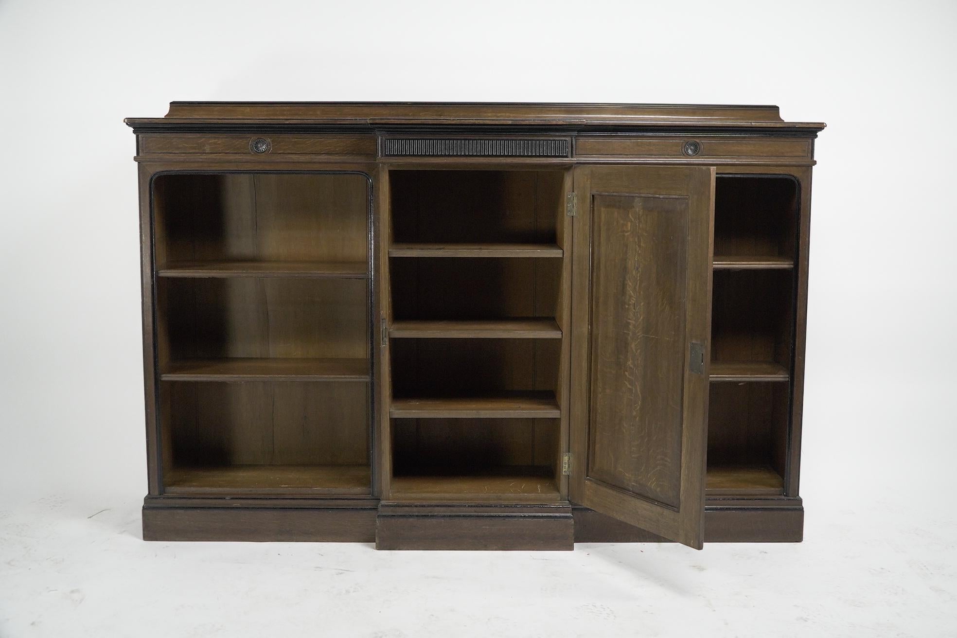English Lambs of Manchester (stamped). A fine Aesthetic Movement oak breakfront bookcase For Sale