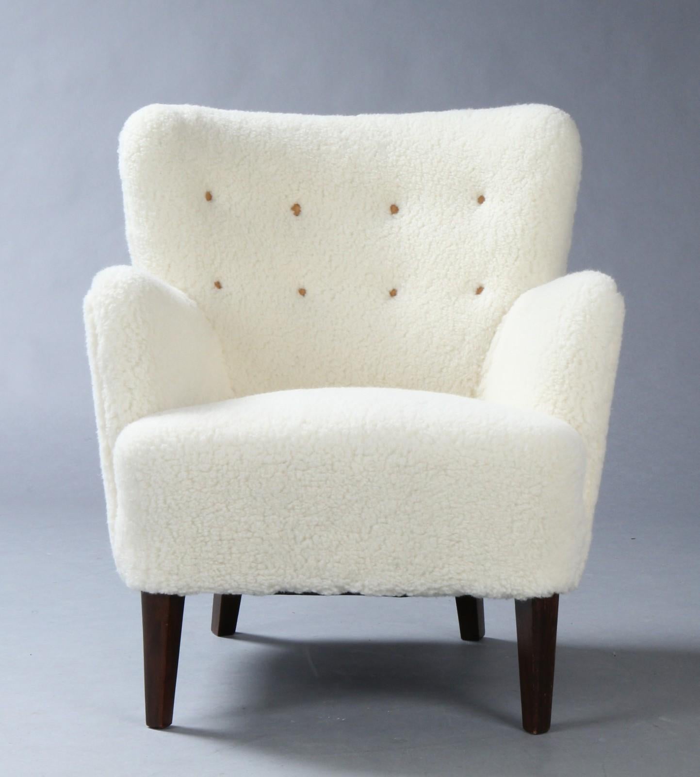 Lounge chair newly upholstered with white sheepskin. Model 1748 designed in the 1950s by Danish super duo Peter Hvidt and Orla Mölgaard Nielsen for Fritz Hansen.