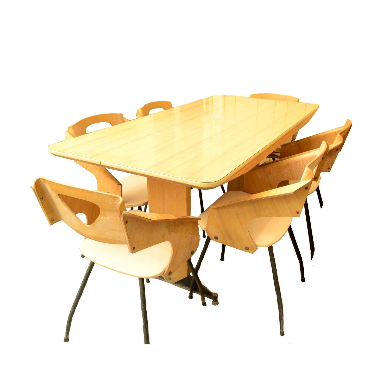 Dining table in laminated wood with wooden and satin finish black metal legs with brass feet adjustable in height, complete with six chairs in plywood and bent, with seat covered with skai, dated back to the end of the forties, that resemble the