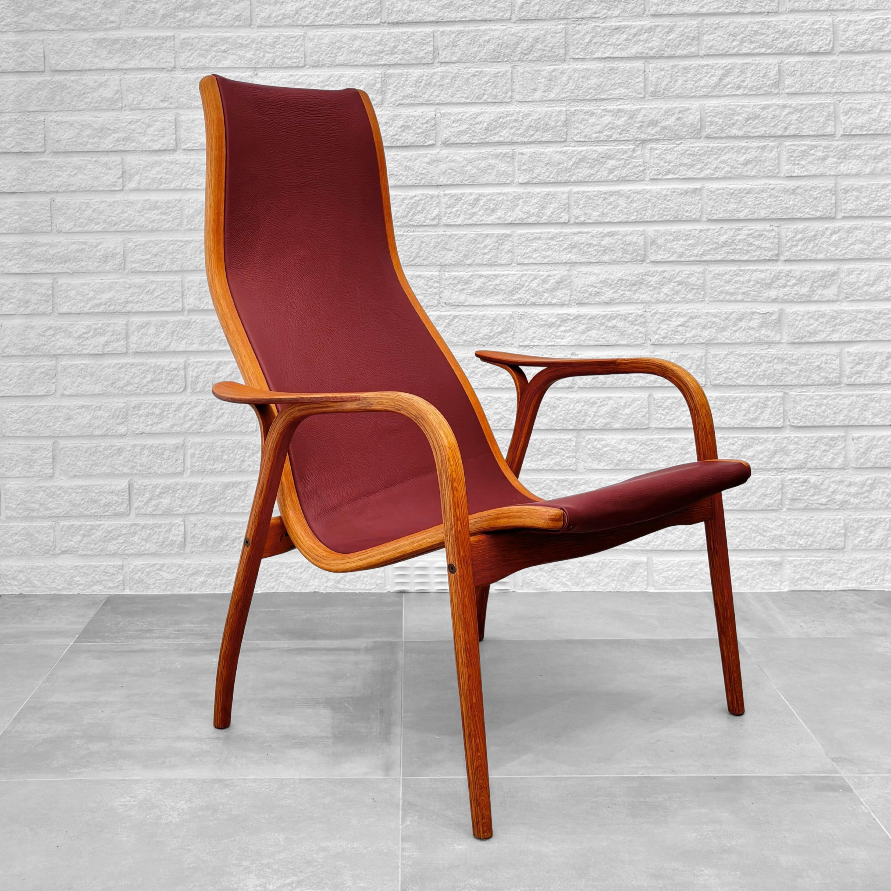 An early 1950s Lamino lounge chair, designed in 1956 by Yngve Ekström for the Swedish manufacturer Swedese in the small town of Vaggeryd. It features a sculptural bentwood frame made from oak with teak armrests and deep red leather upholstery.