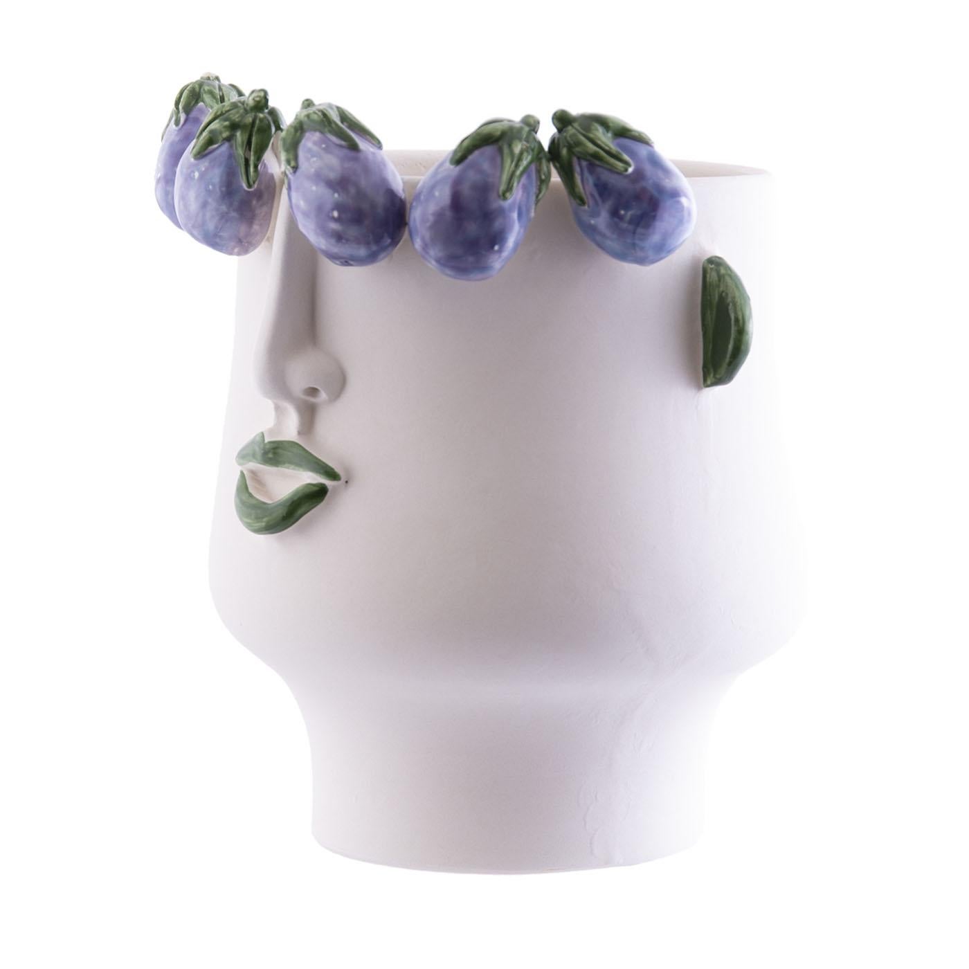 The second fire-fired ceramic head, handmade with face and aubergine reliefs, can be used to contain plants, flowers and sometimes even bottles with ice. 