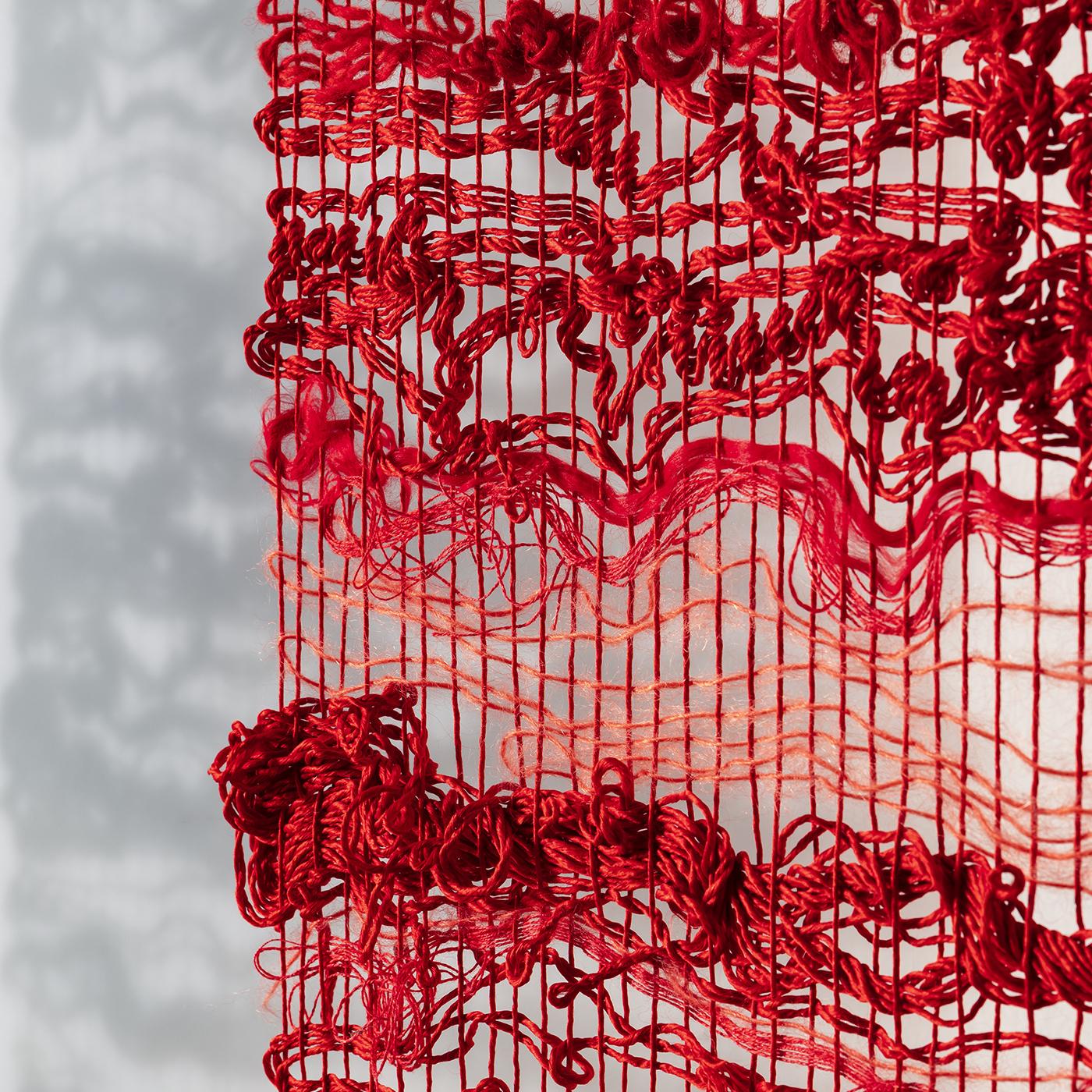 Using traditional techniques in a composition of linen, hemp, silk, shantung silk, wool and cotton, this striking red-toned handwoven vertical tapestry seeks to represent a dialogue on love. For optimal effect, it is best hung 7-10 cm from the wall,