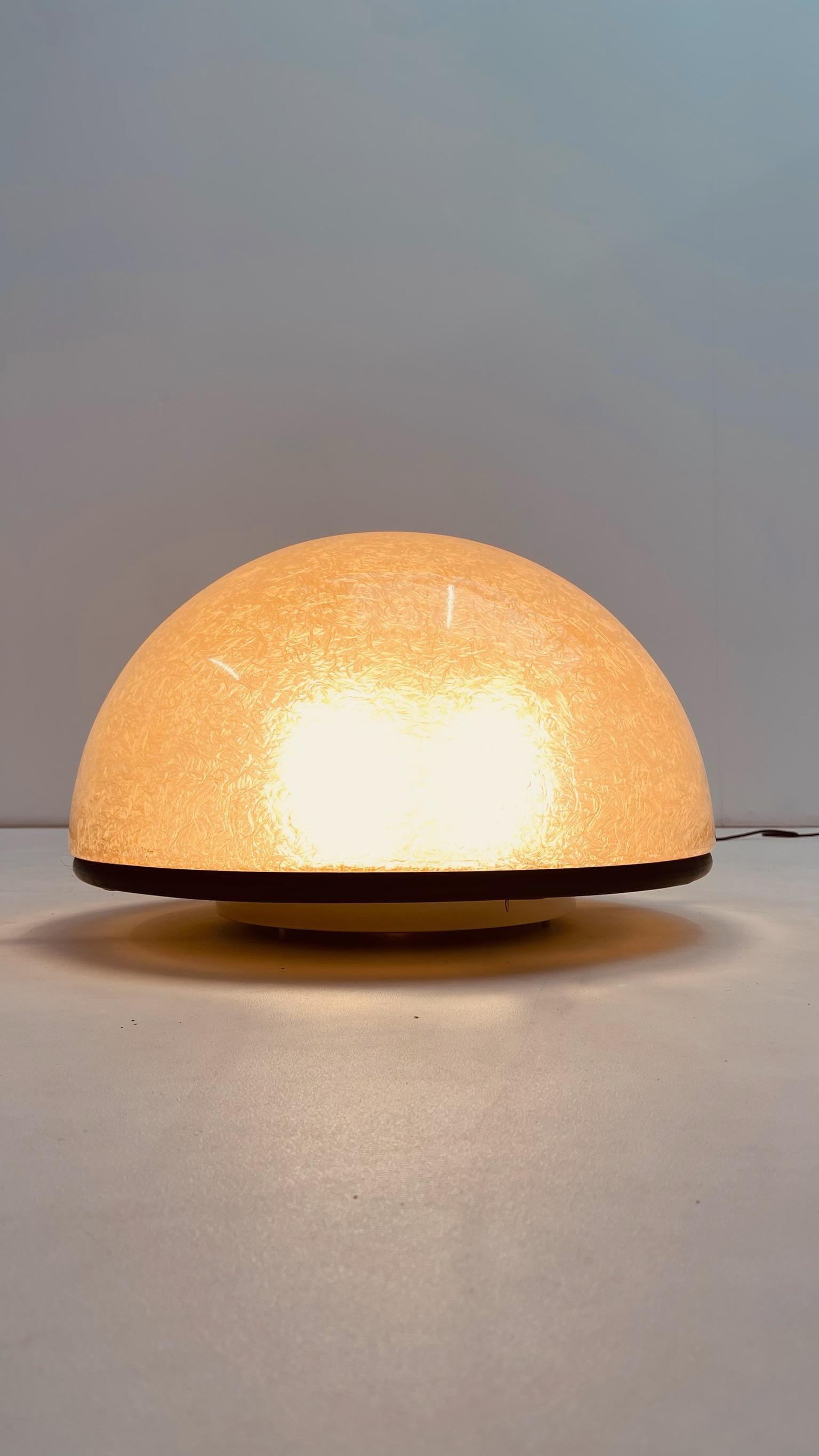 Lámpara de pie, aplique o sobremesa de Luci Illuminazione di interni fabricada en Italia en los años 70.

Pie metálico lacado en negro cerrado por una goma elástica. Media esfera de fibra de vidrio en perfecto estado firmada.
