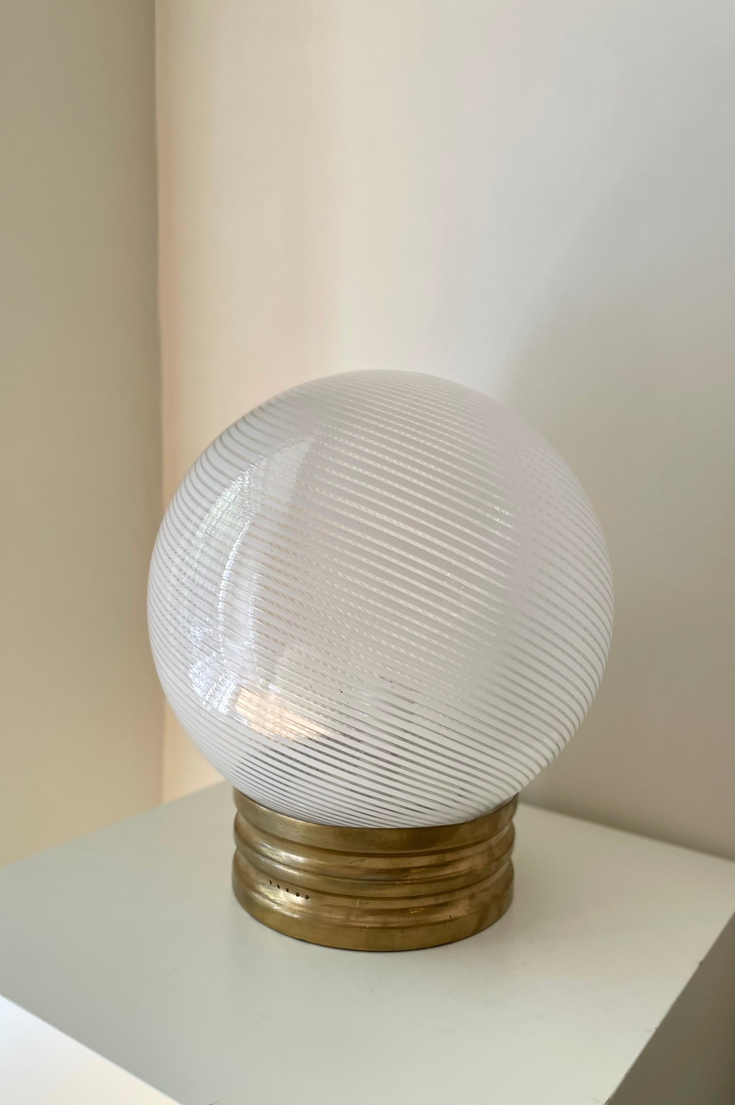 Dante Swirl table lamp by Paolo Venini. With brass base and Murano glass sphere. Italy, 1970s. 

Height: 45cm
Base diameter: 25cm
Sphere diameter: 35cm

Paolo Venini (1895-1959) was an Italian entrepreneur and designer who was instrumental in the