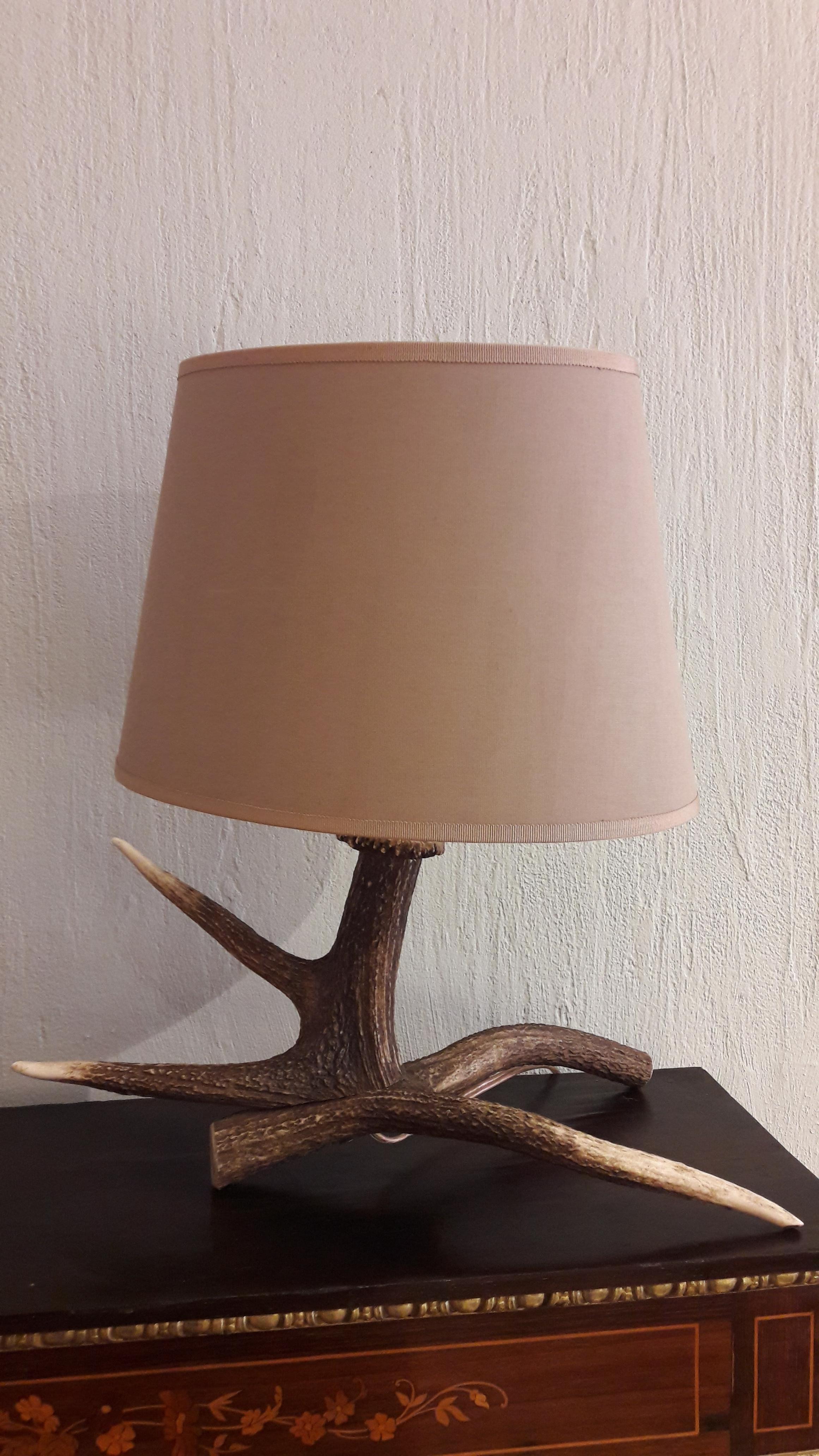 Decorative lamp of a deer horn with lamp shade.