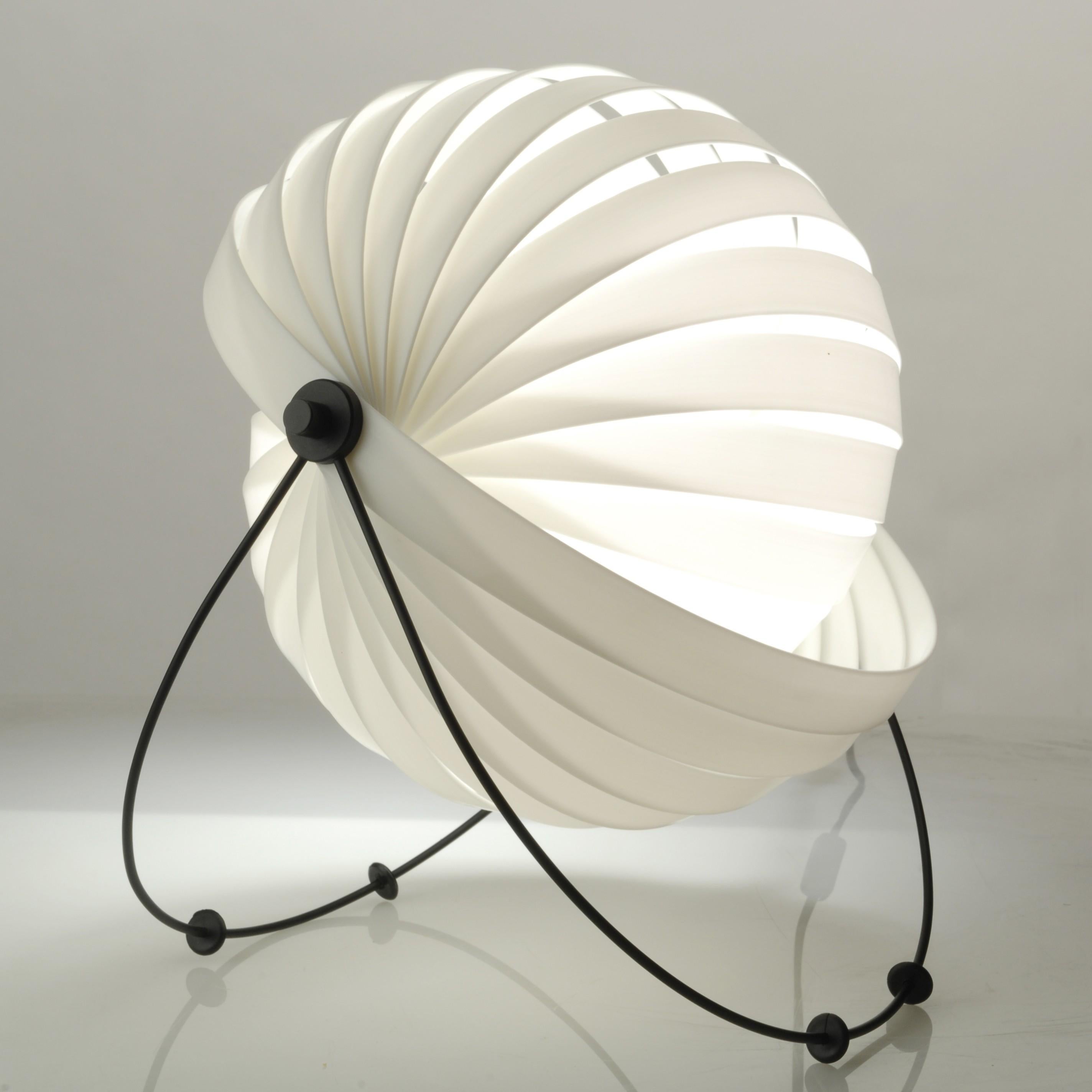 Sculptural eclipse model table lamp. with a snail-shaped dome made of a single spiral-mounted blade and painted iron feet. Vintage piece, 1980s. In working order.

About the Eclipse lamp, Maurício Klabin said: 