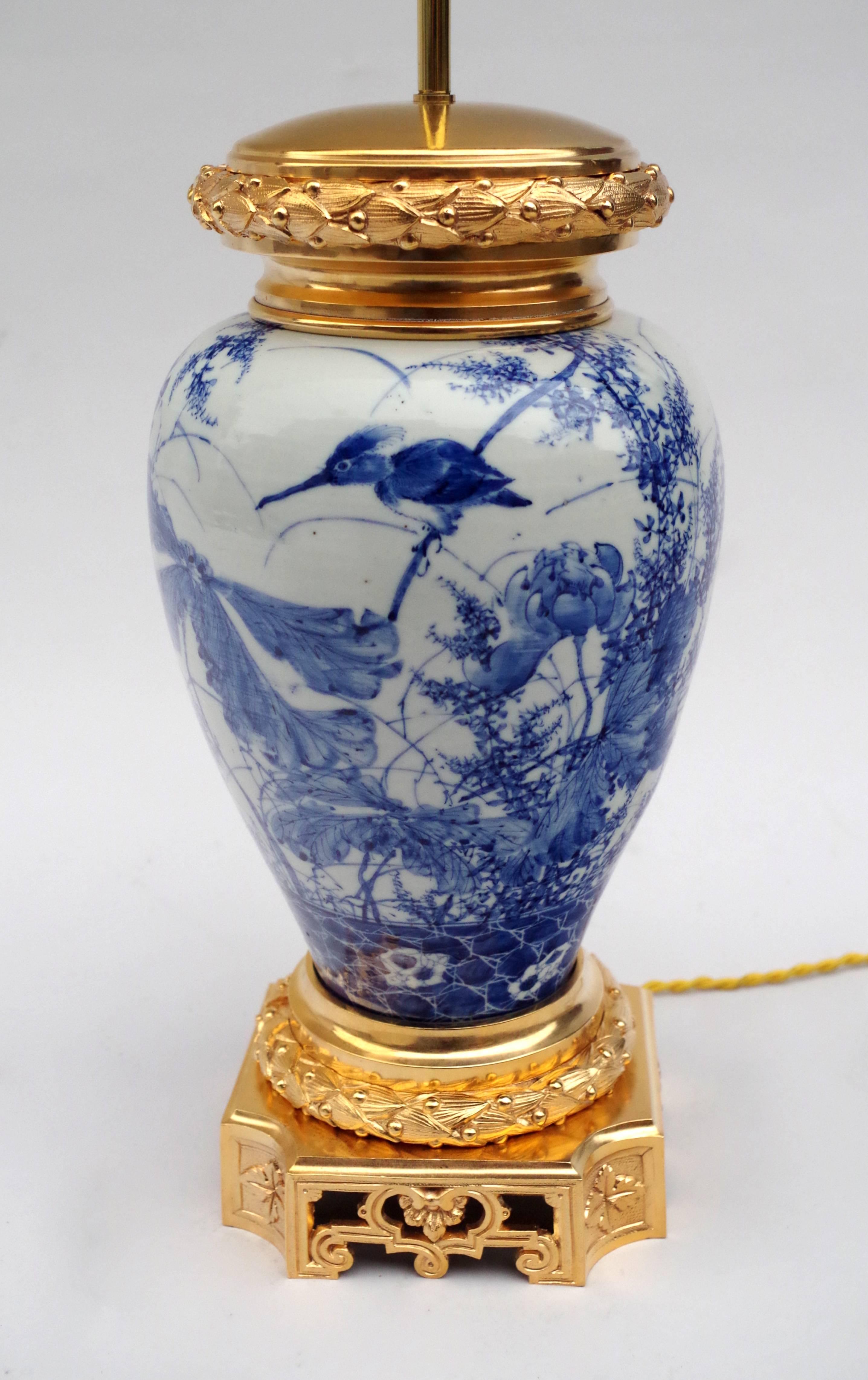 Lamp made with a blue and white far east ceramic, China or Japan, baluster vase mounted in a lamp. The decoration representing a tangle of vegetals and flowers accompanied by a hummingbird, standing on a branch. The lower part is adorned with a