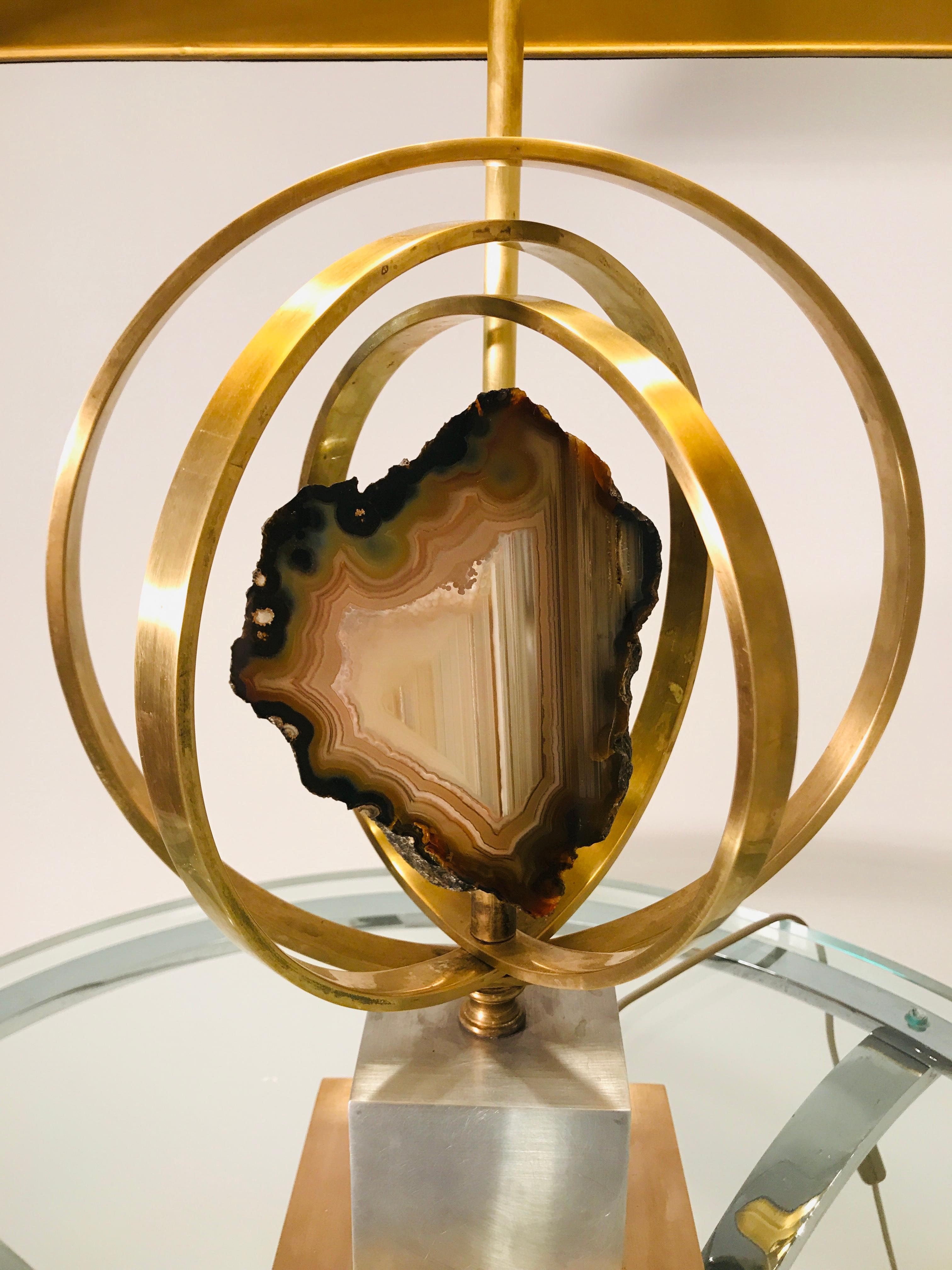 From the 1970s comes this table lamp in cercle brass and gemstone agate. The lamp received new electric al wires according to the latest safety standards. Signed by the artist.
Dimensions: 42cm x 28cm x 70cm H.
without shade: 25cm x 25cm x 70cm H.