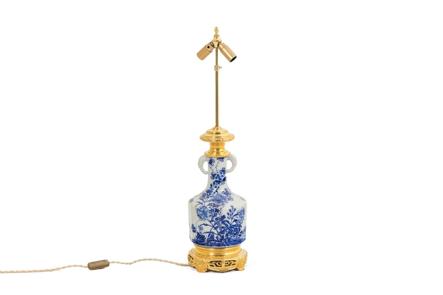 Baluster-shaped Japanese porcelain lamp with floral decoration, in blue tones. Gilt bronze mount. Quadripod base, top of the frame adorned with gilt rhinestones.

Work realized circa 1880.

New and functional electrical system.

!The price