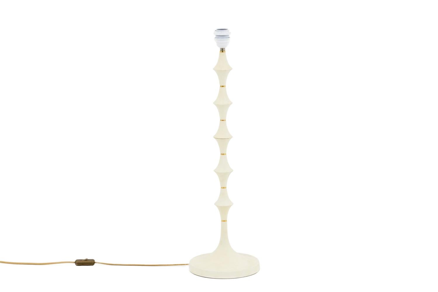 Lamp in white resin and gilt brass. Shaft in stylized stacked hourglasses shape standing on a circular base.

Work realized in the 1970s.

New and functional electrical system.

The price doesn’t include the lampshade price. However, our