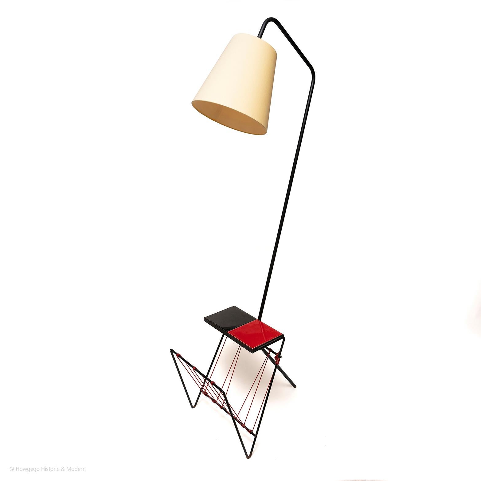 Striking, angular, sculptural piece 
Multi-purpose functioning as a lamp, sidetable, shelf and magazine rack.
Dramatic red and black colouring.

Black powder sprayed angular metal framework. Red and black tile tray table top or shelf with