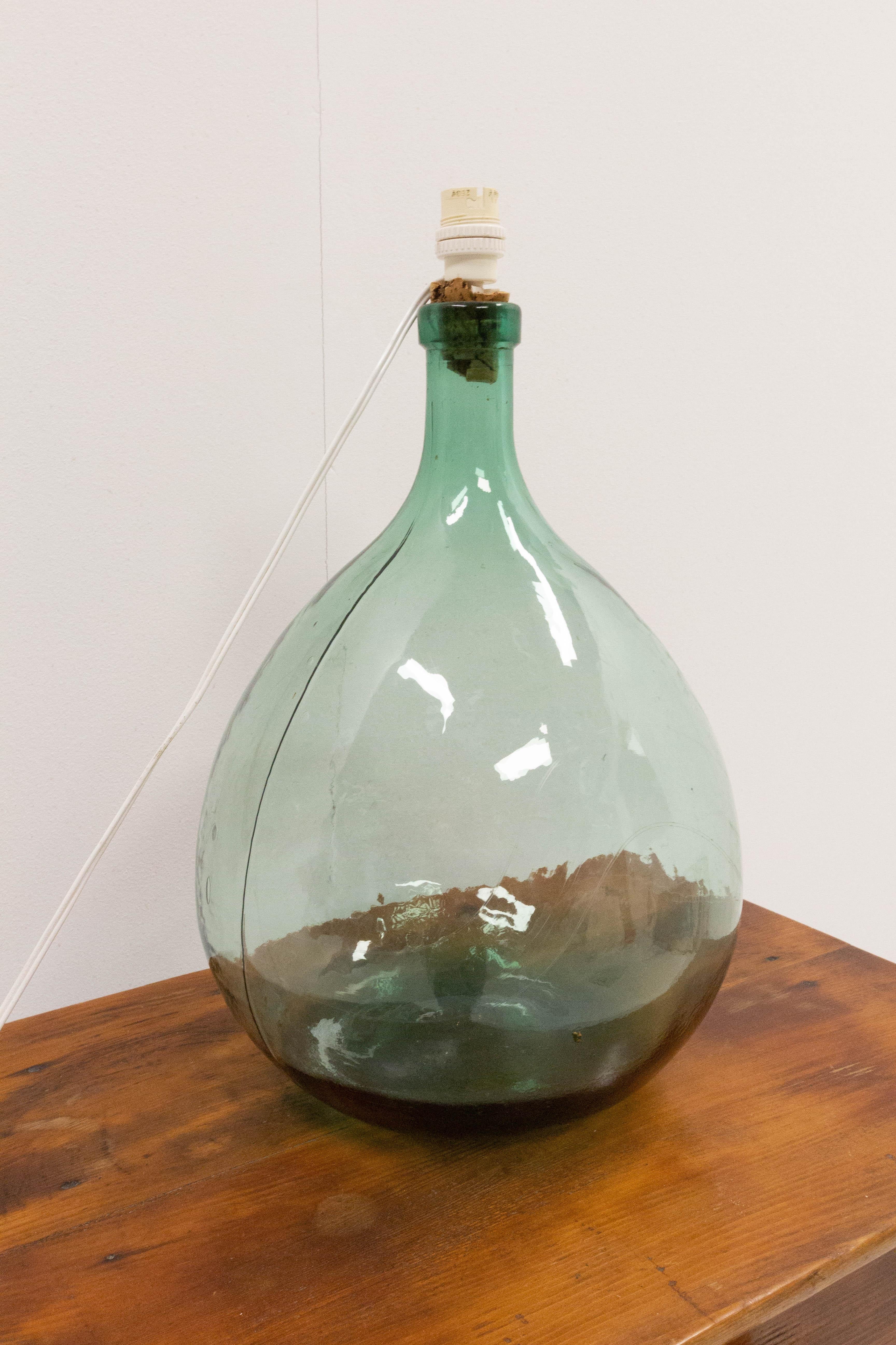 Lamp mounted on a dame jeanne or carboy vintage green glass bottle demijohn
Irregularities in the glass that gives it all its charm
This can be rewired to USA or EU and UK standards
Very good condition.

Shipping:
wooden case 38 55 48 cm 10