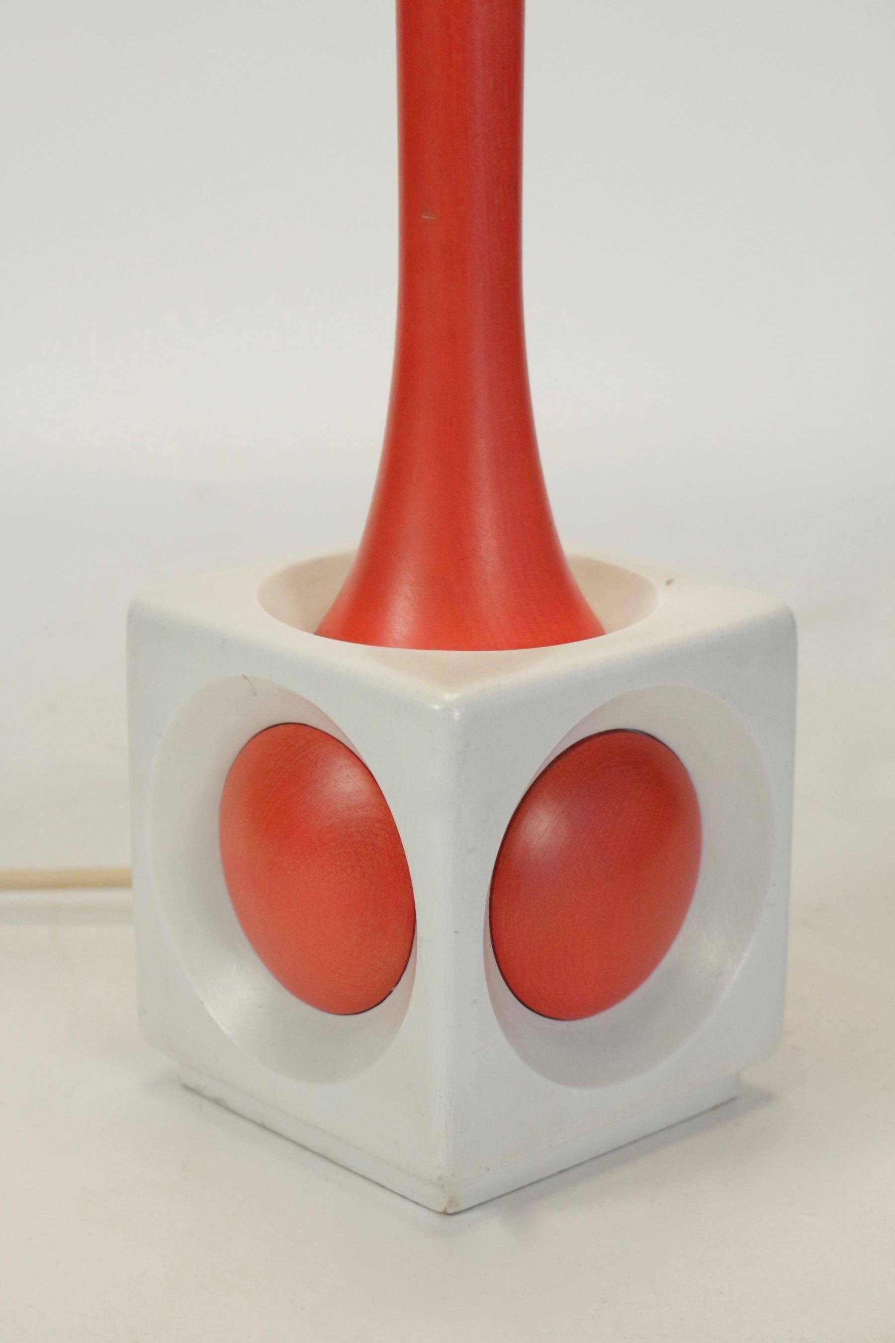 A lamp of wood painted orange and white, circa 1960, midcentury design.
  
