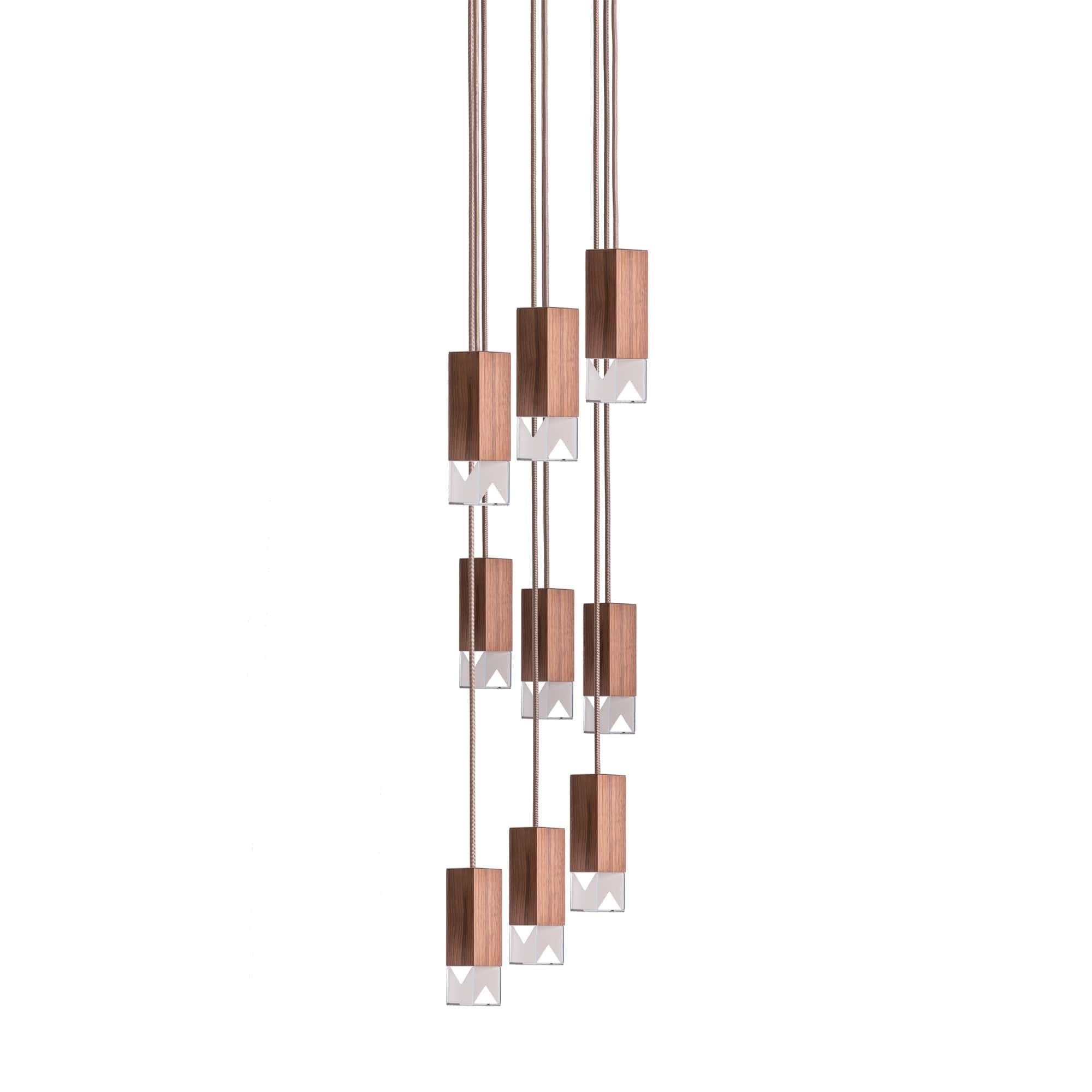 Lamp one 9-light chandelier in walnut by Formaminima
Dimensions: H 111.9 x 30 x 30 cm
Materials: Lamp body in walnut, oil finish

Ultra-thin anti-reflection crystal diffuser
Inside-diffuser Limoges biscuit-finish porcelain sheets
Satin brass