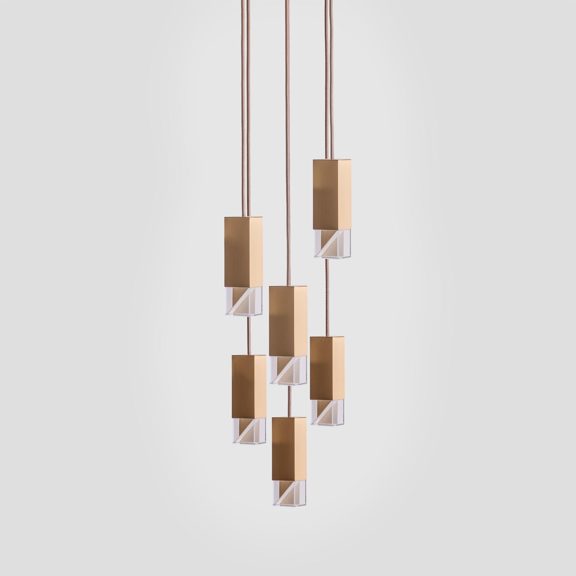 Marked by a minimal design, this exquisite chandelier of the Lamp/One Collection is a fine example of contemporary aesthetic and traditional craftsmanship. Suspended from the ceiling from a square satin brass plate (30x30cm), six fabric cables
