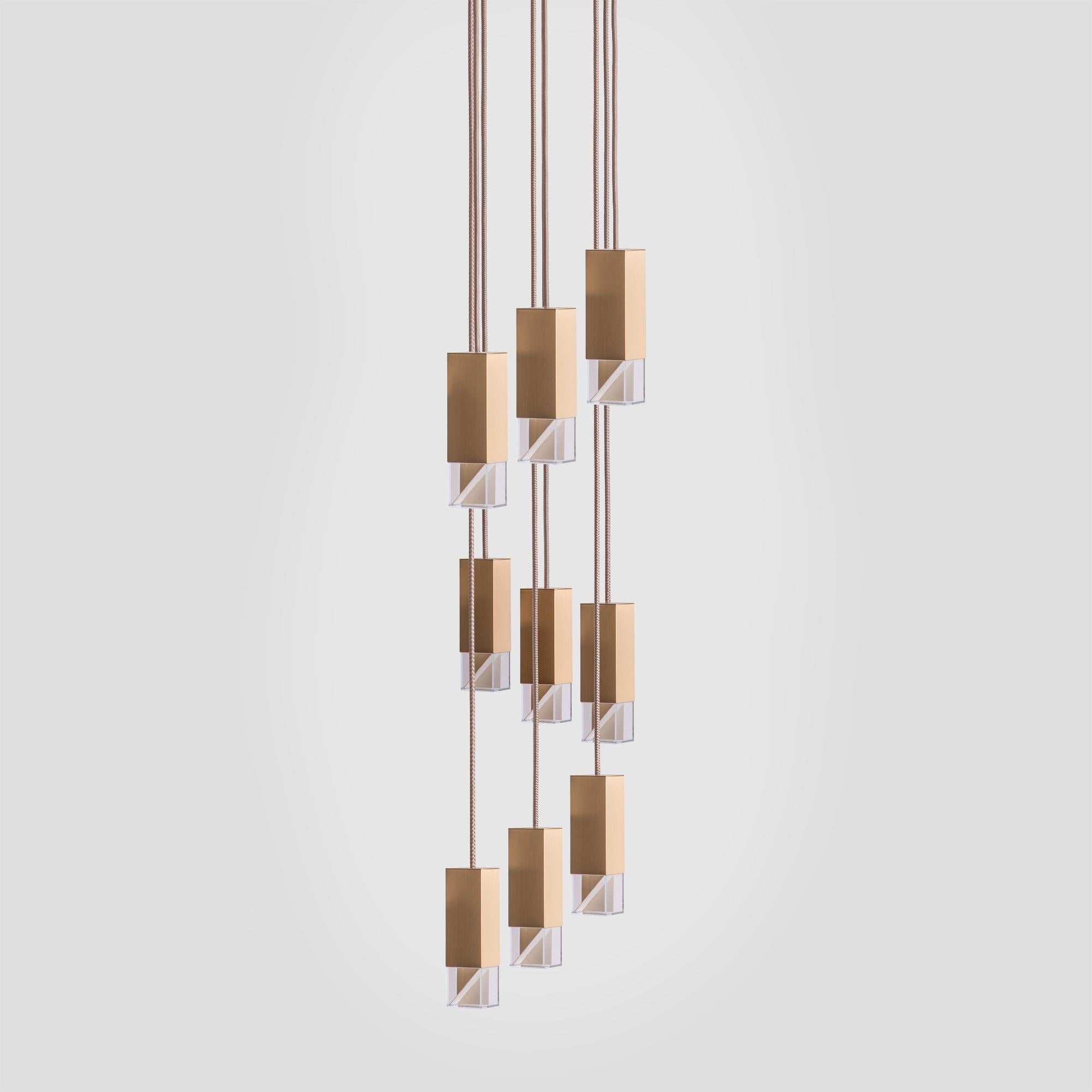 This stunning chandelier will be a captivating addition to any high-ceiling interior, where its architectural construction can be showcased in full details. Composed of nine shades suspended from a square satin-brass ceiling plate (30 x 30cm) with