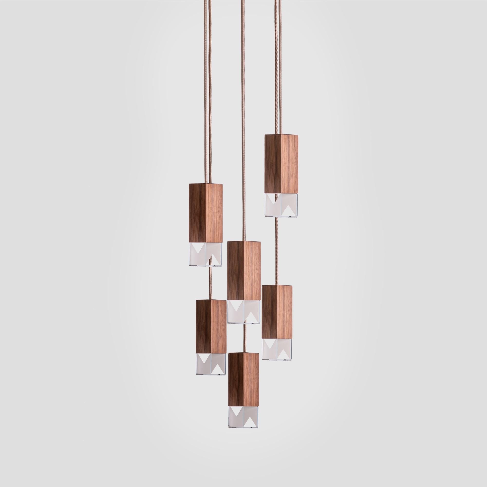 Combining a simple and elegant shape with prized materials, this modern and sophisticated chandelier features six pendants hanging from a square ceiling plate (30 x 30cm) of satin-finished brass at different lengths from adjustable fabric cables (2m