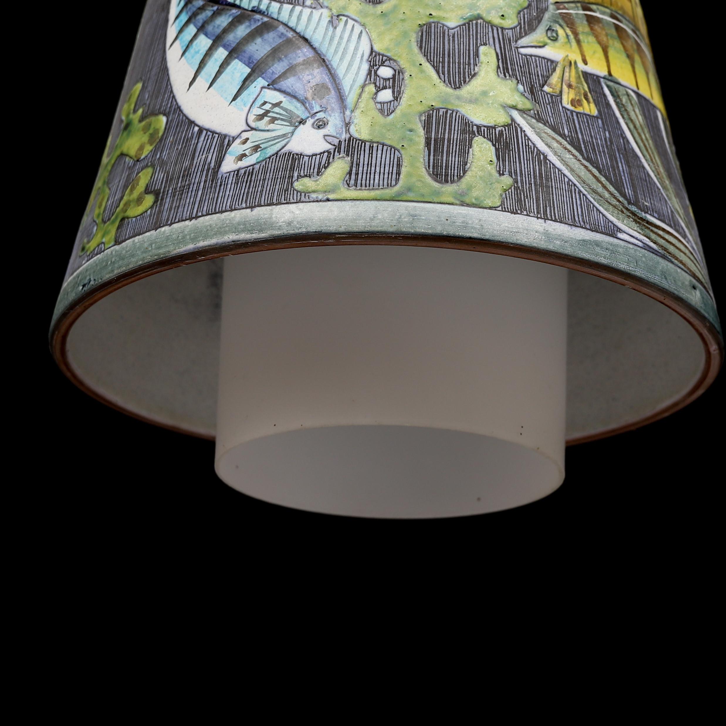 Lampada a sospensione Probabilmente Marian Zawadsky per Tilgmans Keramic realizzata in Svezia intorno al 1960
Paravento affusolato con decorazione dipinta a mano di pesci e alghe. Schermo interno cilindrico in vetro bianco opaco. Montatura conica in