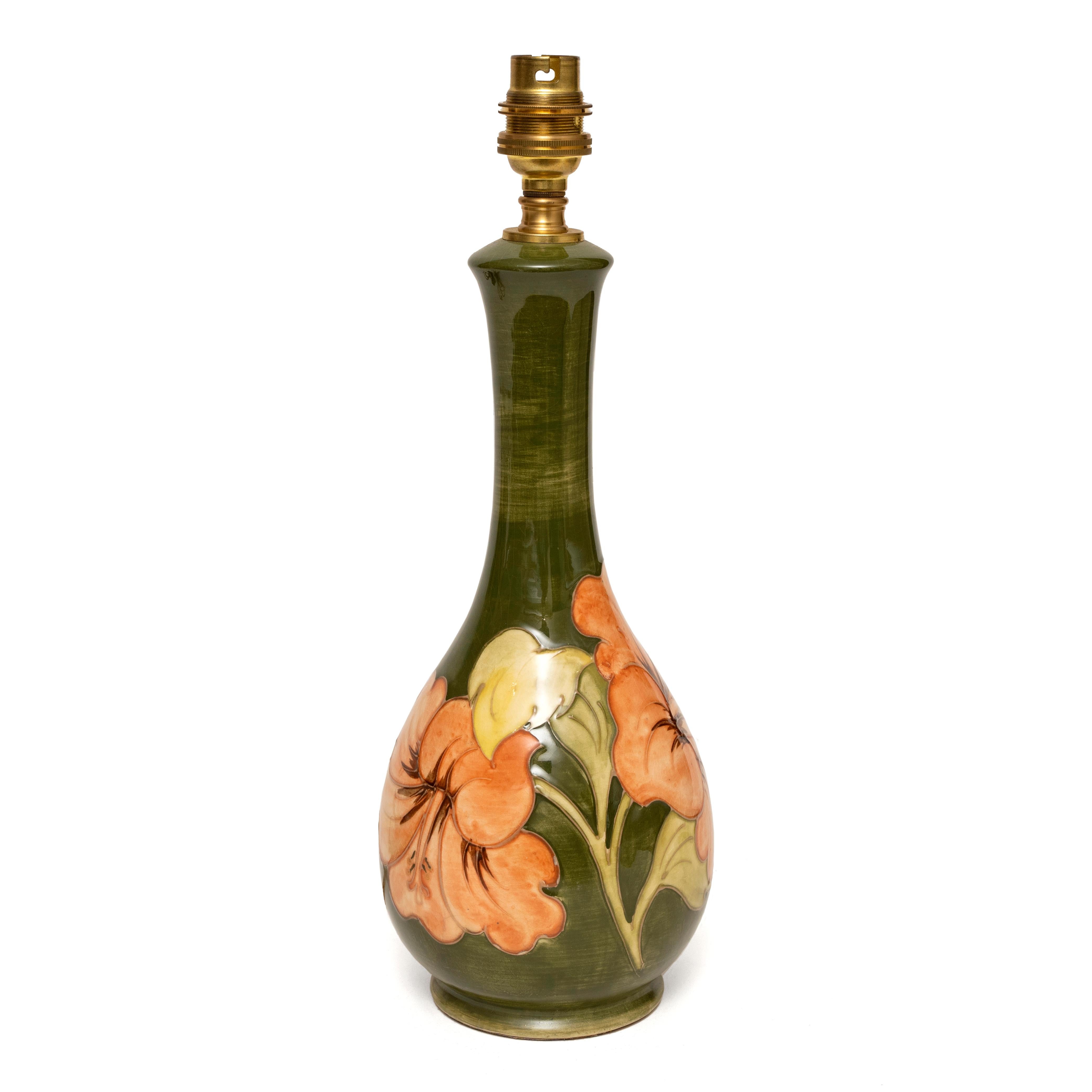 Moorcroft, hibiscus pattern, bottle vase, upcycled into a table lamp, 13½ ” high
Naturalistic, introducing the exotic floral garden into the interior
Elegant, slender bottle form.
Decorated in relief with large coral flowerheads with green leaves