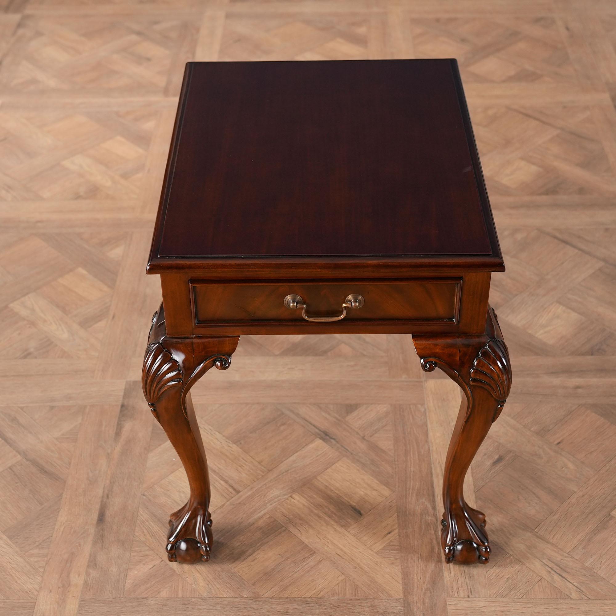 A Chippendale style Ball and Claw Mahogany Lamp Table produced by Niagara Furniture with an attractive mahogany top surrounded by a lovely molding and over a frame containing a dovetailed drawer. The entire Lamp Table is supported on hand carved,