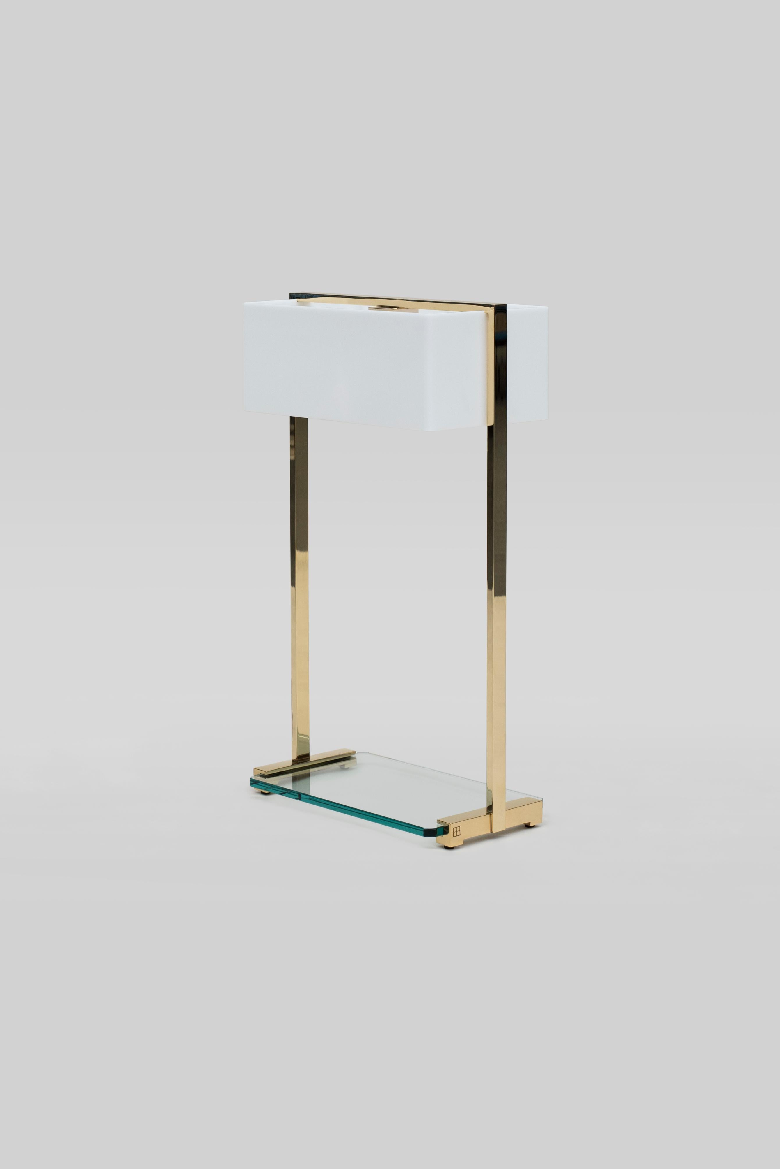 This 21st century minimalist Tom MW10 table lamp was designed by Peter Ghyczy in 2006 and hand-crafted in the GHYCYZ atelier in the south of the Netherlands, with a select group of artisans. The polished and glossy brass frame is made of 1 x 2 cm