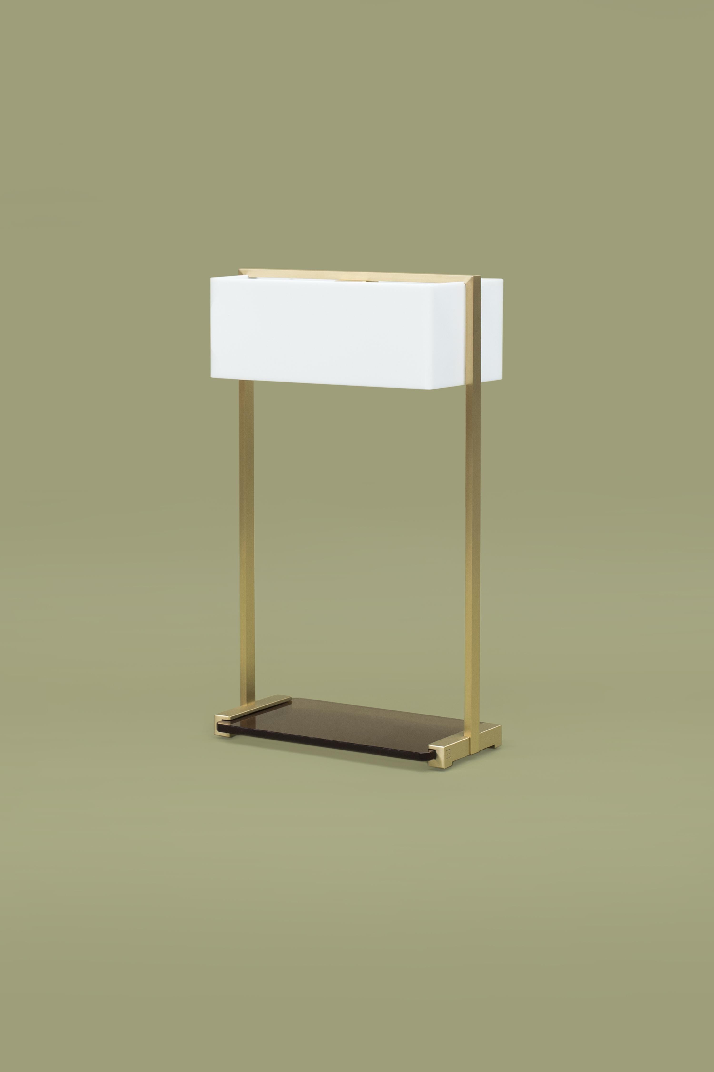 This 21st century minimalist Tom MW10 table lamp was designed by Peter Ghyczy in 2006 and hand-crafted in the GHYCYZ atelier in the south of the Netherlands, with a select group of artisans. The brass frame, with a smooth matte finish, is made of 1