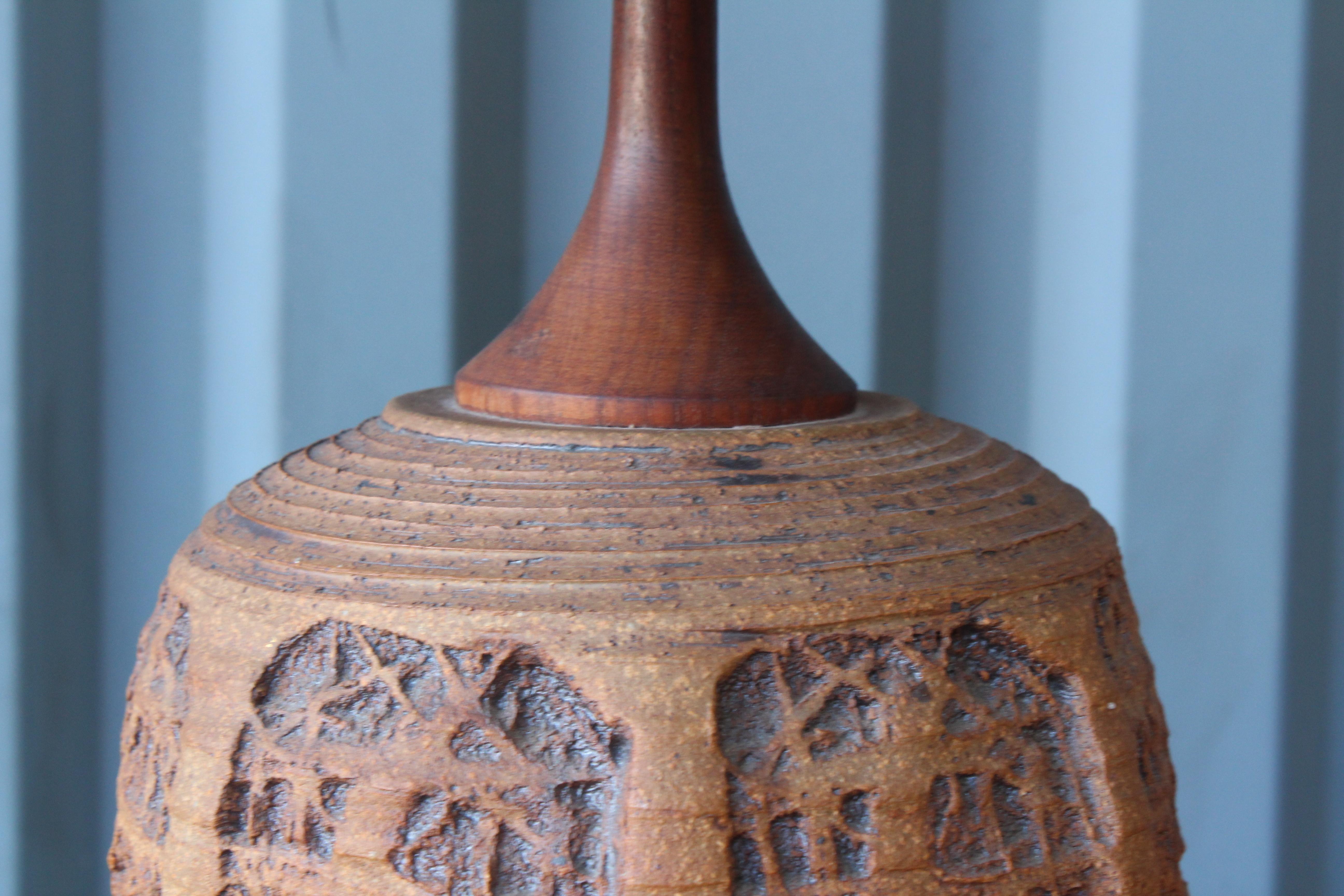 Stoneware table lamp with solid teak stem and fitted with a custom made jute shade. Made by ceramist Tom McMillin in the 1960s in Southern California. Newly rewired.