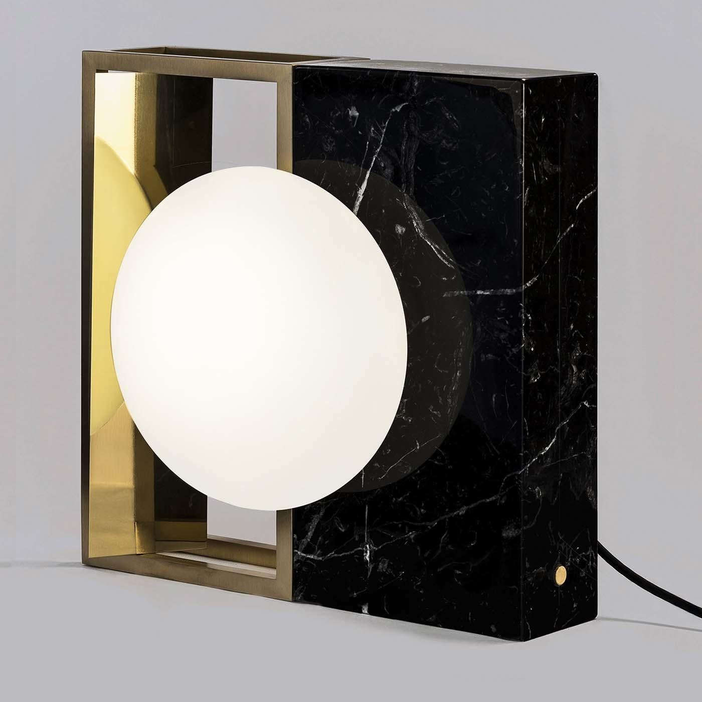 Each lamp by Hagit-Pincovici embodies a multiplicity of forms and textures resulting in an entirely modern work of functional decor. This sculptural lamp features a hand-blown Murano glass orb embedded in a square frame, half as an open brass frame
