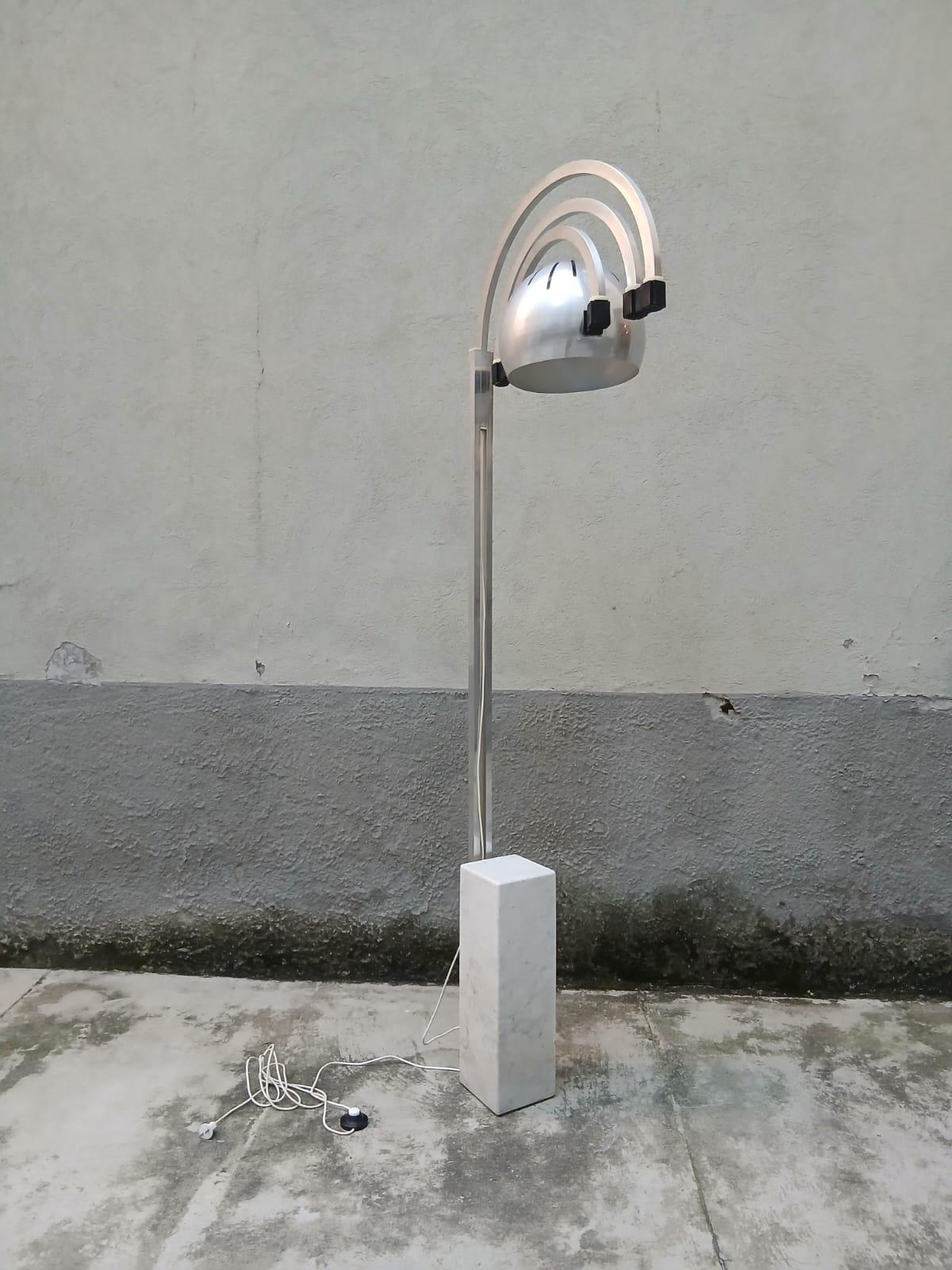 Luminaire à arc extensible raffiné de Goffredo Reggiani pour la société Reggiani du même nom, fabriqué en Italie dans les années 1970. La structure en métal satiné est greffée sur un socle en marbre blanc massif qui fait office de contrepoids,
