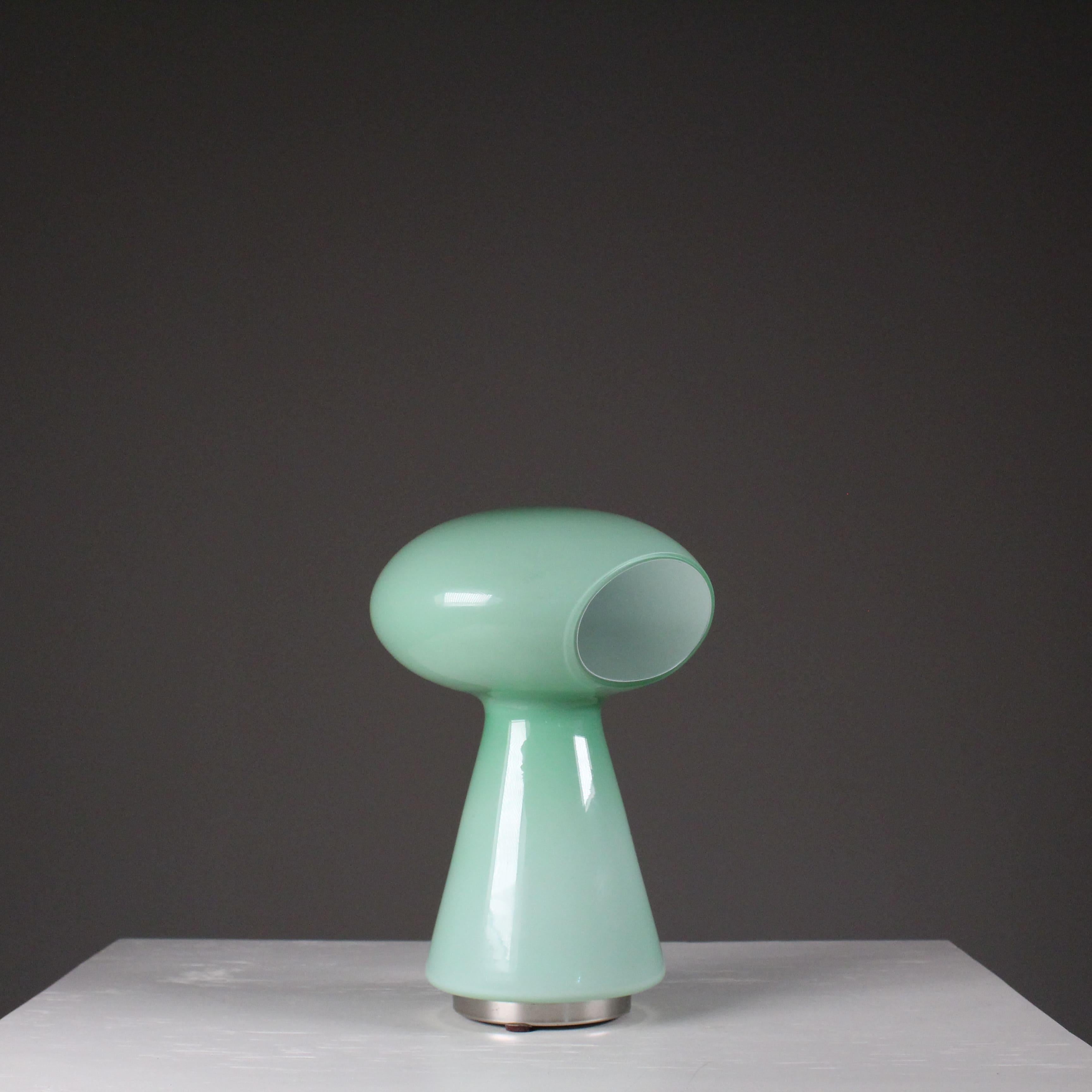 Elegante e iconica, questa lampada a forma di fungo è realizzata in pregiato vetro di Murano verde dalla storica vetreria Vistosi. Caratterizzata da linee morbide e una luminosità avvolgente, incarna il perfetto equilibrio tra artigianato
