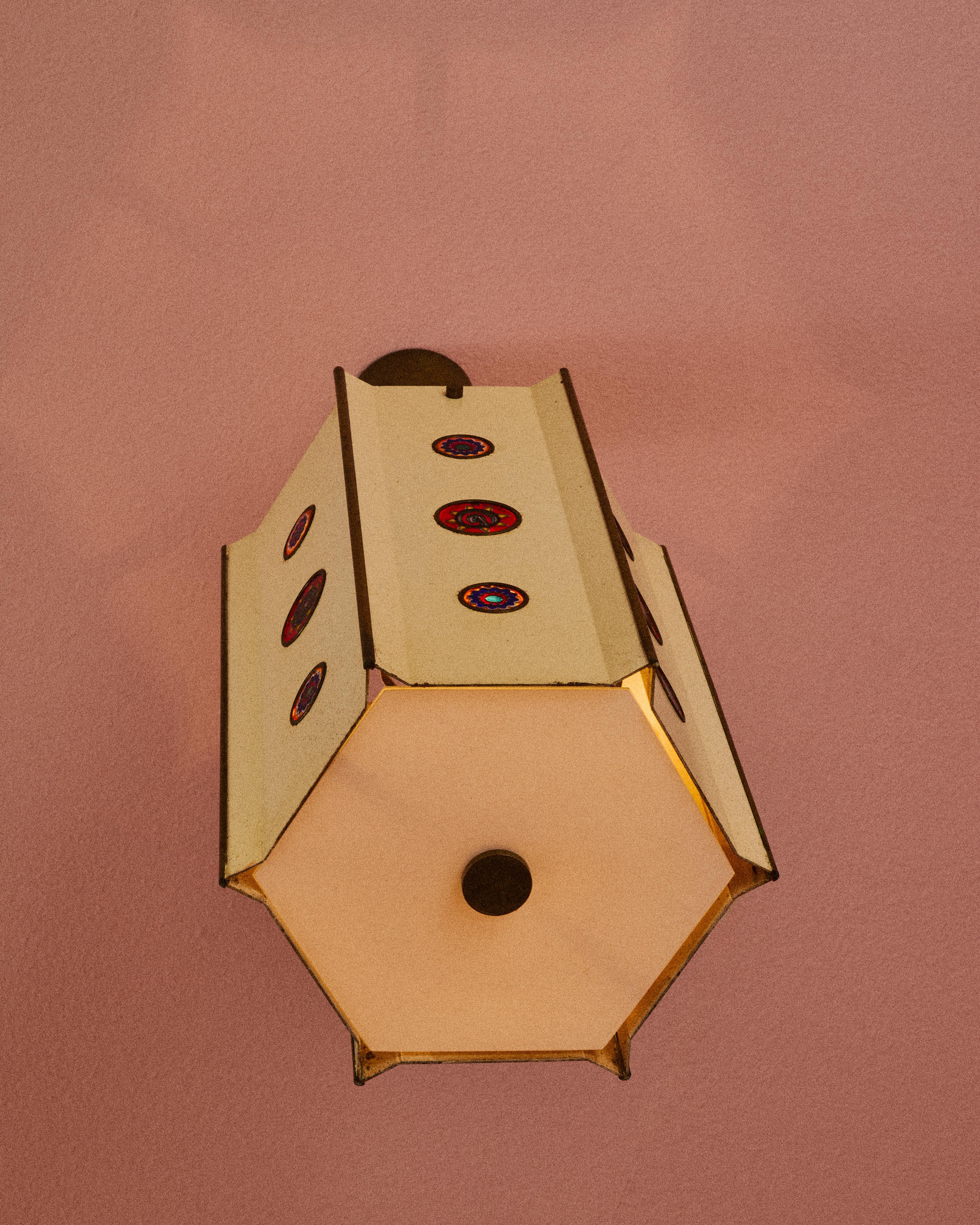 Elegante e pregiata lampada a sospensione in ottone lucido verniciato, con diffusore in vetro lattimo e inserti in murrine. Disegno di Angelo Lelii per Arredoluce, Italia, 1966.
L’uso delle murrine, che Angelo Lelii acquistava direttamente a Murano
