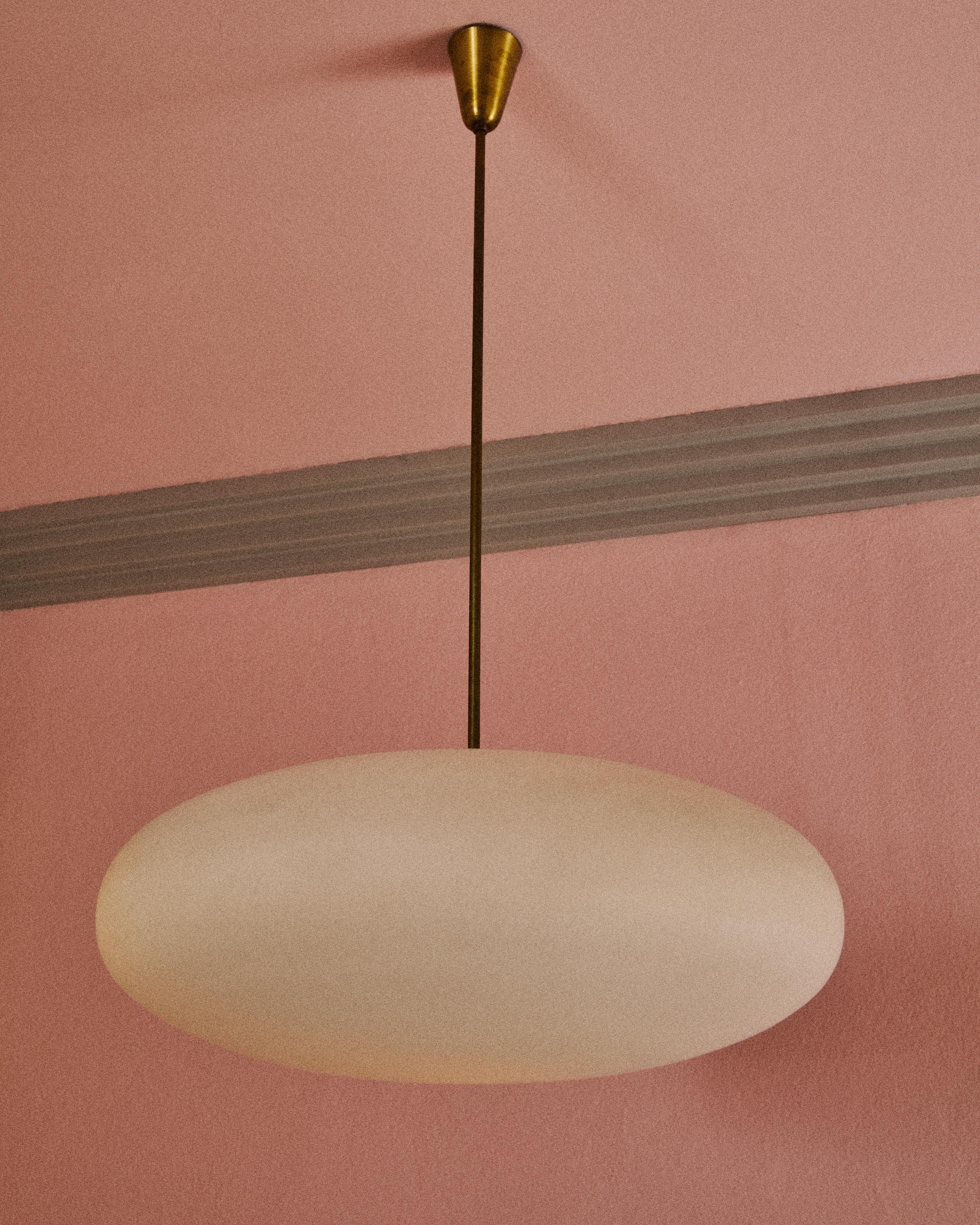 Lampada a sospensione con struttura in ottone lucido e grande diffusore a forma ovoidale in vetro opalino. Disegno di Angelo Lelii per Arredoluce, anno 1958. 