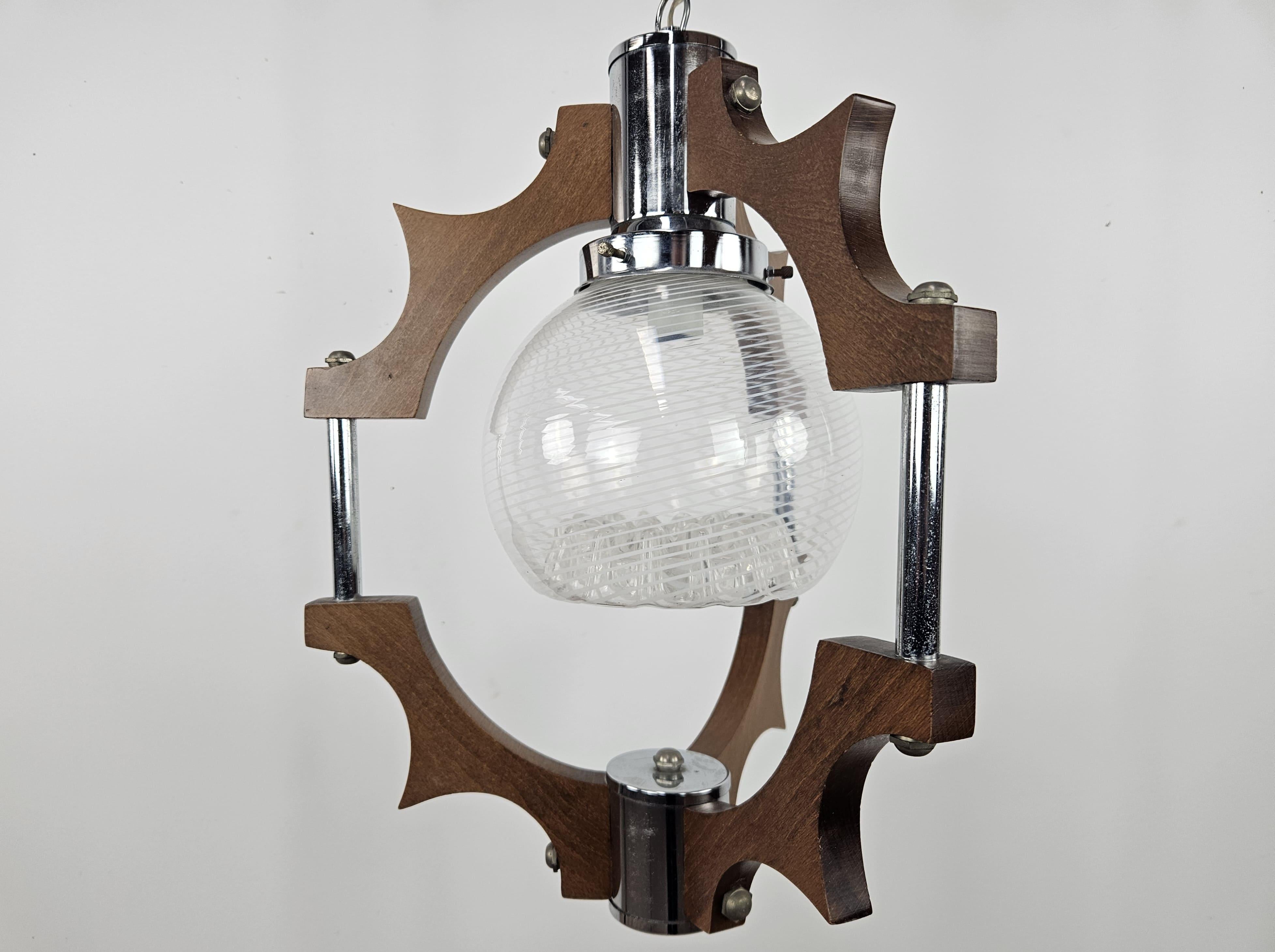 Italian chandelier from the 1970s with a wood and metal frame, enhanced by a beautifully worked and decorated ceiling light.

Original electrical system of the time, recommended replacement.