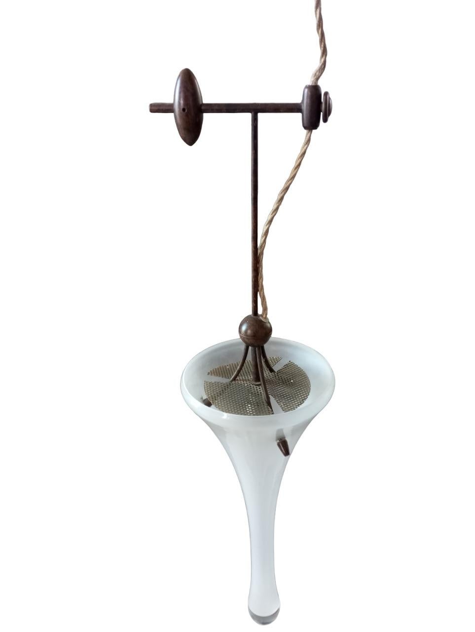 Lampada pendente, in vetro di Murano bianco, a forma di cono, risalente agli anni ’60, con eleganti rifiniture in legno e bronzo. L’altezza del vetro è di 40 cm, mentre l’altezza totale fino alla rifinitura in legno raggiunge i 70 cm. Il diametro