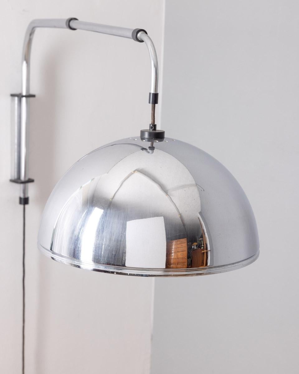Lampada da parete in metallo cromato, regolabile in larghezza, ed in altezza è tramite il contrappeso in cui si trova l'interruttore, design Italiano, anni 70.

CONDIZIONI:
in buone condizioni, funzionante, presenta segni d'usura dati dal