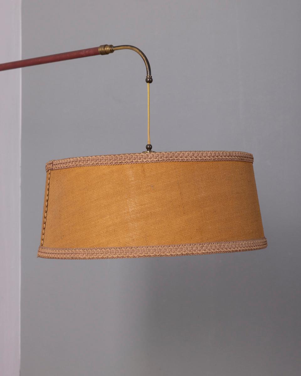 Lampe de table avec structure en ottone dorato et inserto en pelle bordeaux, paralume en tessuto decorato. Regolabile in profondità e altezza tramite il contrappeso in ottone dove è posizionato l'interruttore, design italiano, anni '50.

CONDIZIONE
