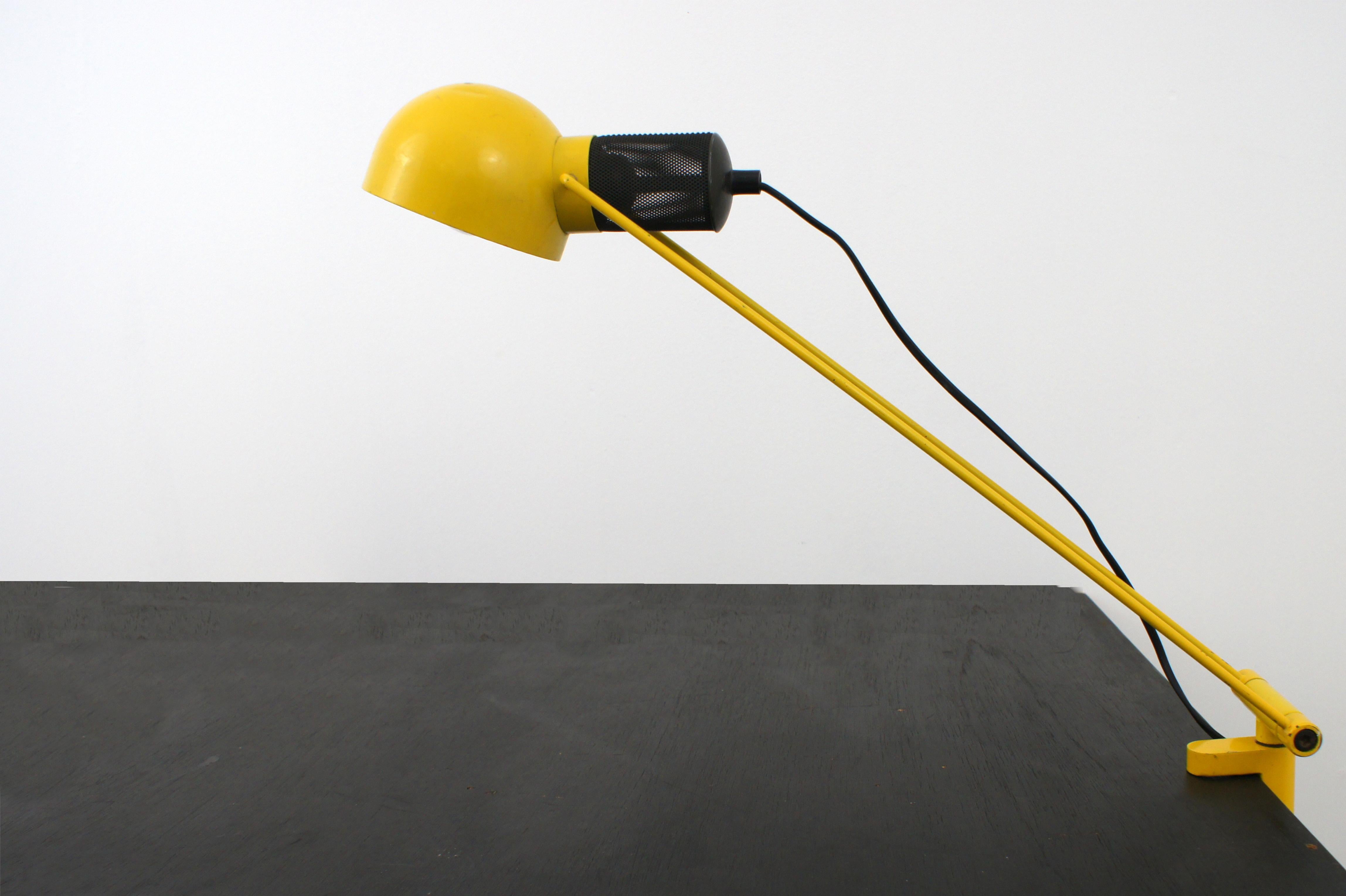 Italian-made desk lamp from the 1980s.

Lacquered metal frame. 

Adjustable in frame and projector tilt, pivoting. attaches to desk with clamp system. 

It mounts a bulb with E27 pitch.