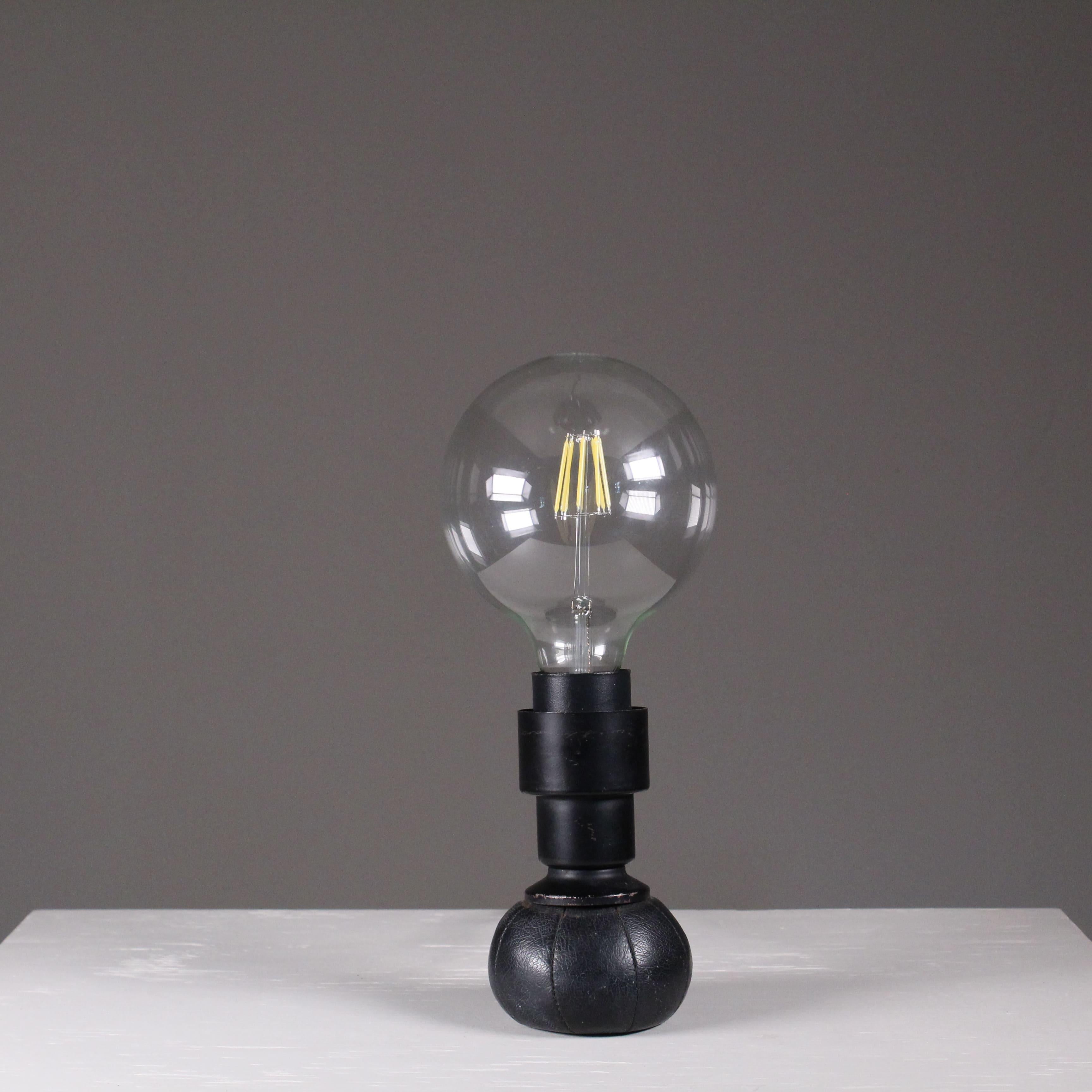 Entworfen von Gino Sarfatti im Jahr 1966, produziert 1960 - 1969. Der Ledersockel ist mit kleinen Bleikugeln gefüllt, die es ermöglichen, die Lampe in verschiedenen Positionen zu halten.