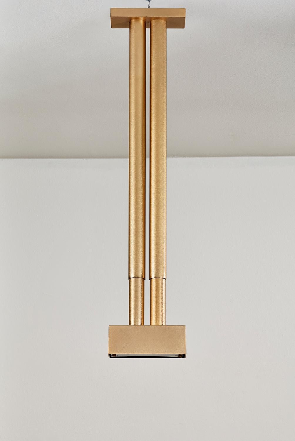 Lampada da soffitto Mallet disegnata da Roberto Giocoli e prodotta da Sirrah nel 1985. Con una altezza regolabile fra gli 80 ai 140 cm, la lampada Mallet possiede un corpo in alluminio placcato oro. La sua struttura geometrica ed essenziale permette