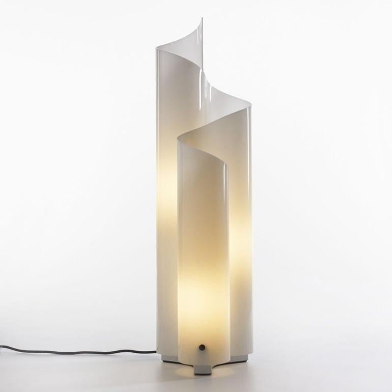 Lámpara de mesa modelo Mezzachimera de la casa productora Artemide, diseñada por Vico Magistretti en los años 70.
La base de la estructura es de metal y el difusor, con sus curvas sinuosas, está modelado con una niebla de metacrilato opalino.

El