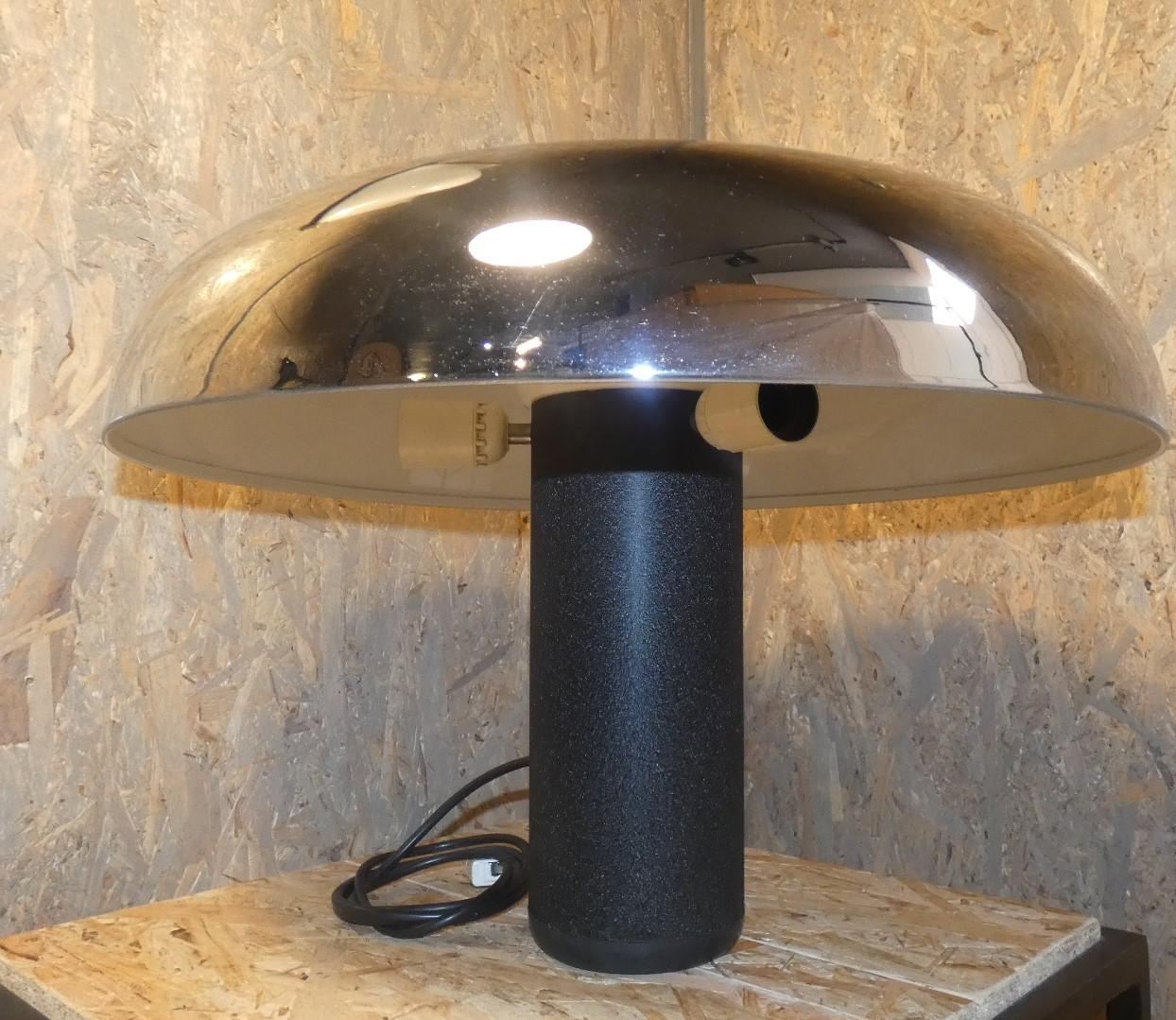 Circa lamp, produced in the 1970s by Lumenform . The prominent chrome-plated lampshade is enameled on the inside in ivory,  has pressure ignition on the top through the  large black button. The column base has a heavy weight and is made of black